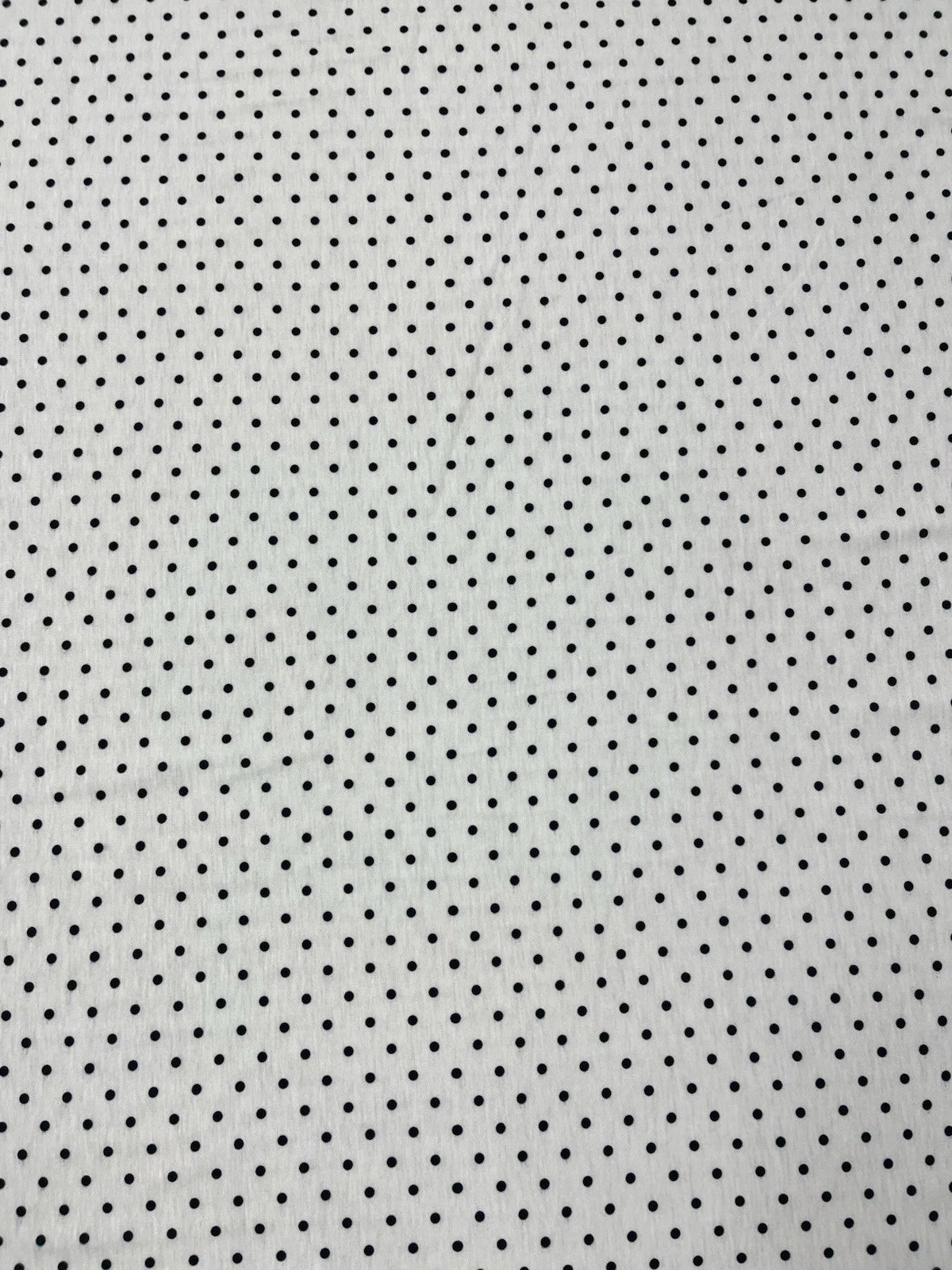 White fabric with small black polka dots