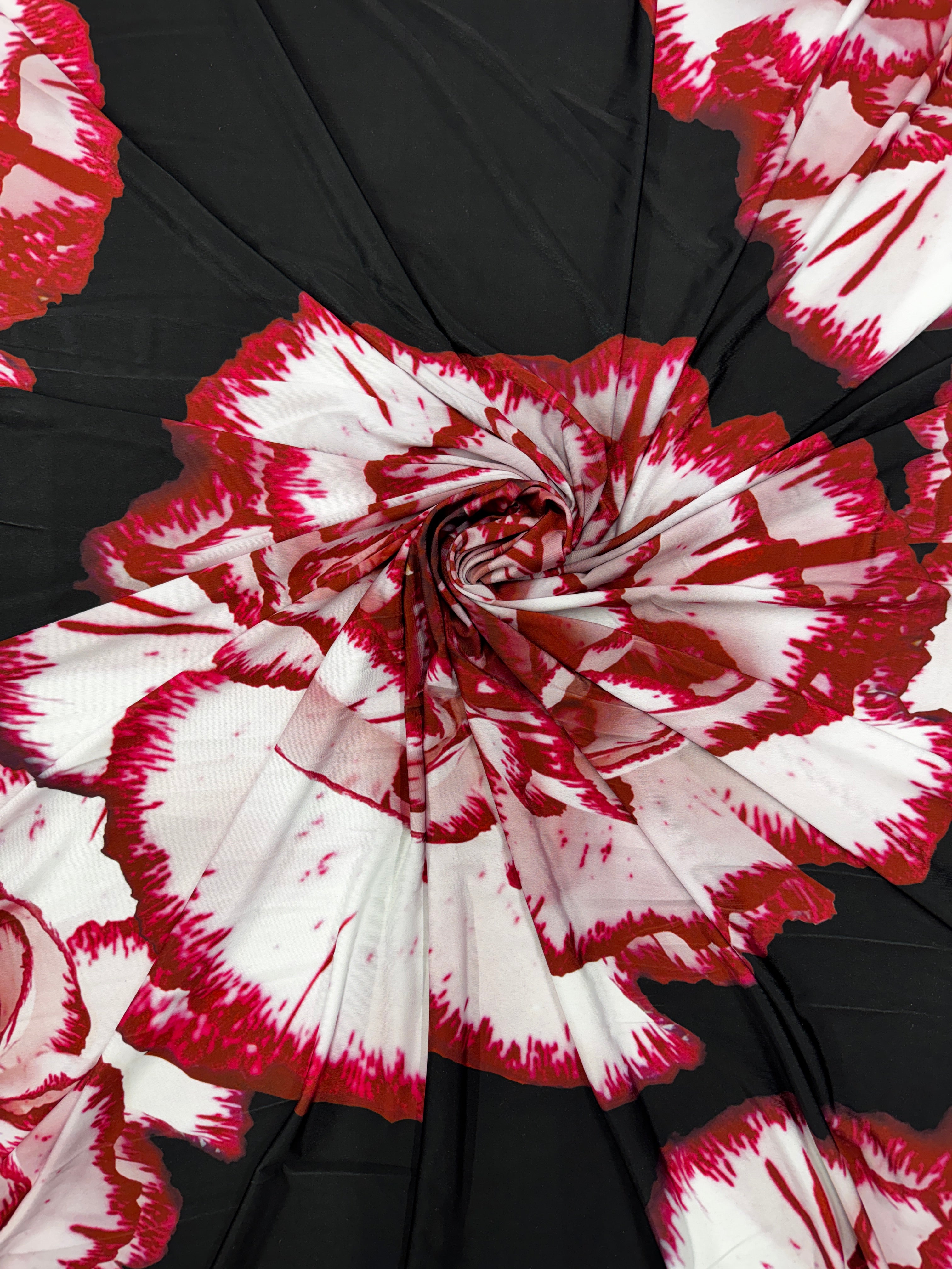 Textured surface of black and red floral slinky fabric