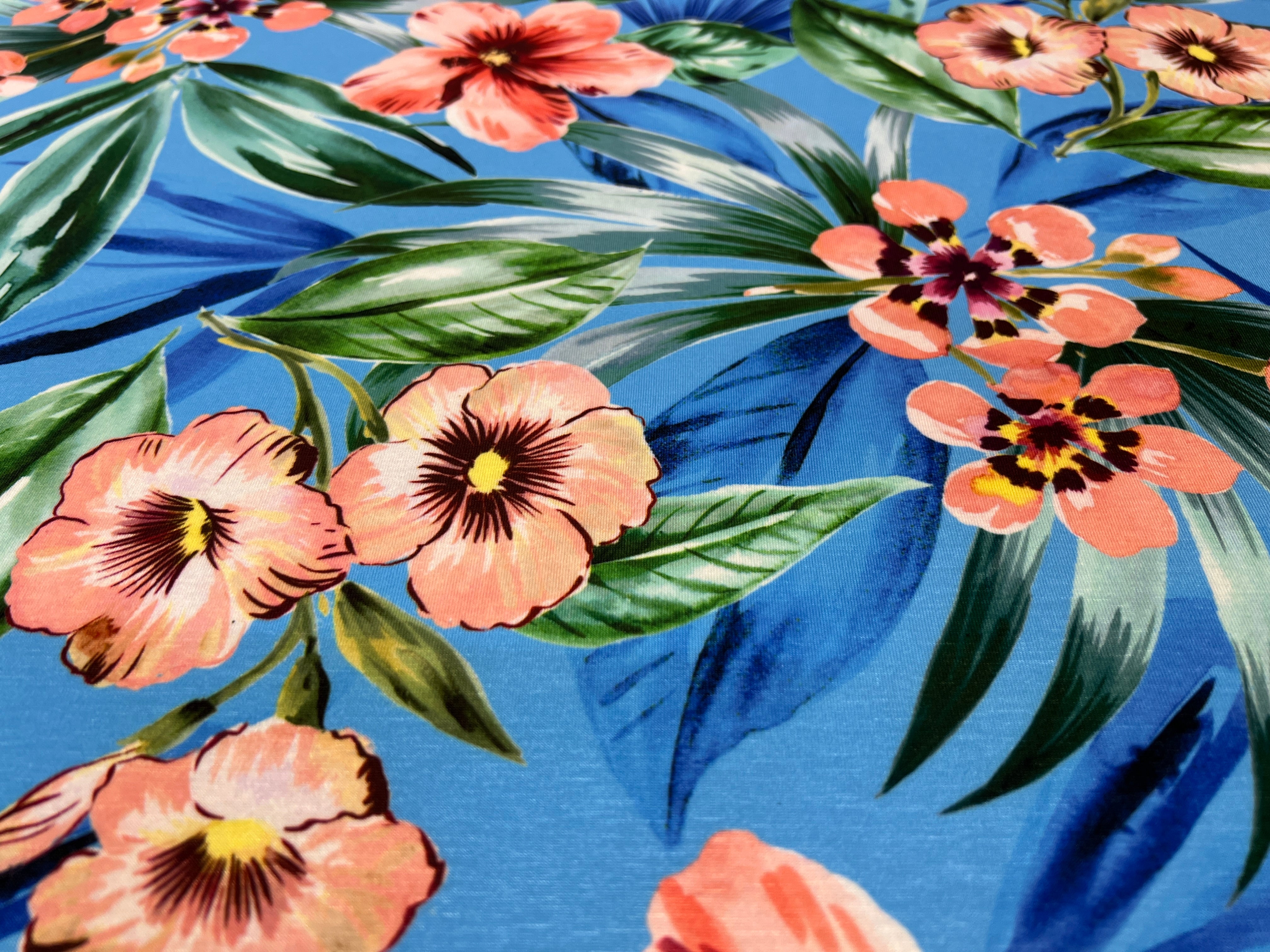 Floral pattern with pink flowers and green leaves on a blue background