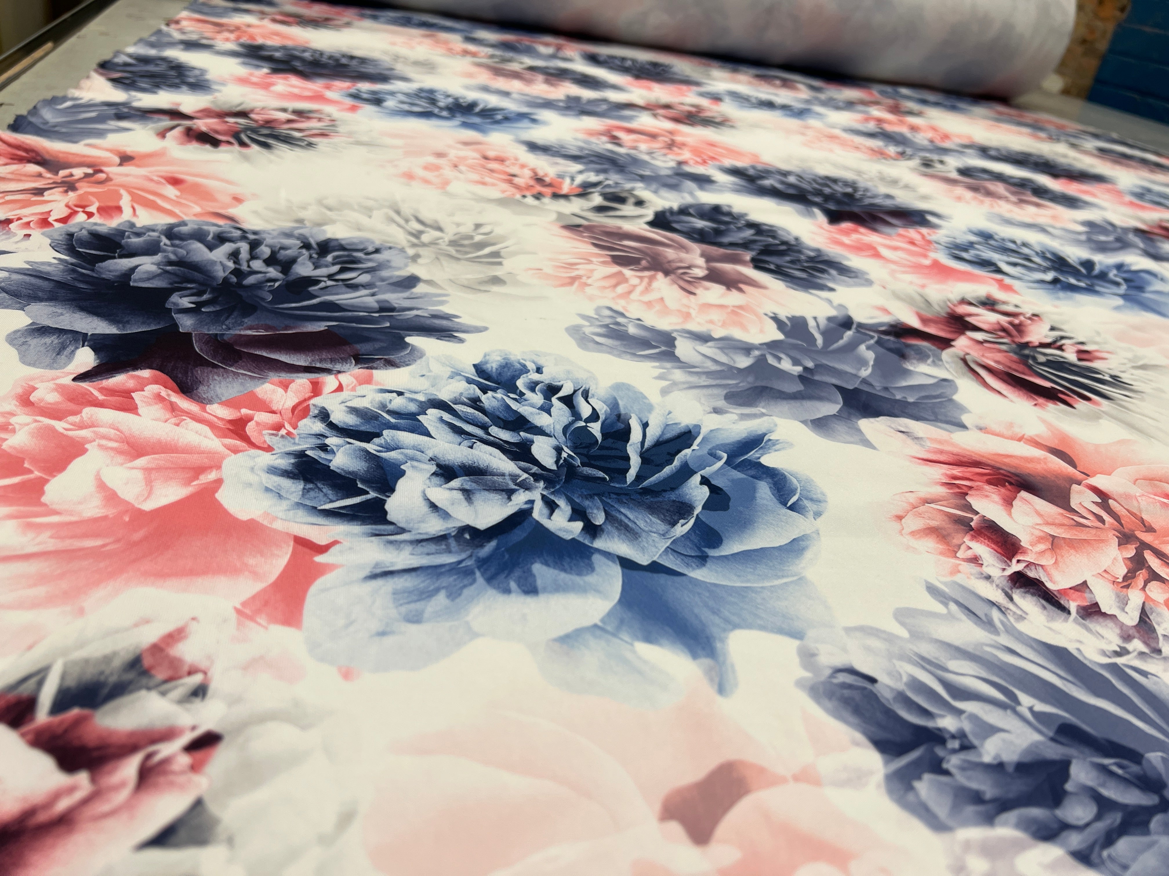 Close-up of a floral fabric with pink, blue, and white colors.