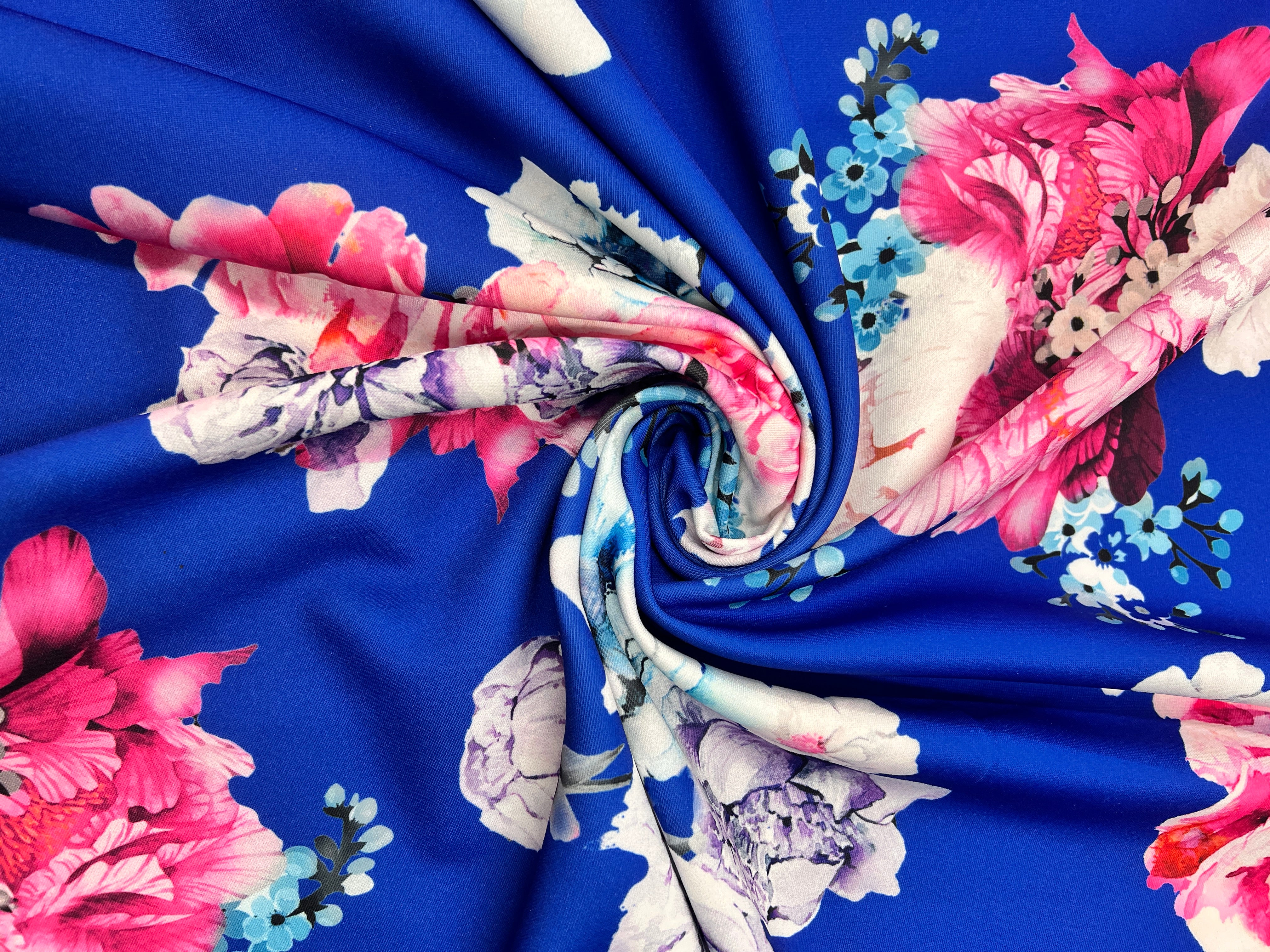 Floral fabric with pink, white, and blue flowers on a blue background
