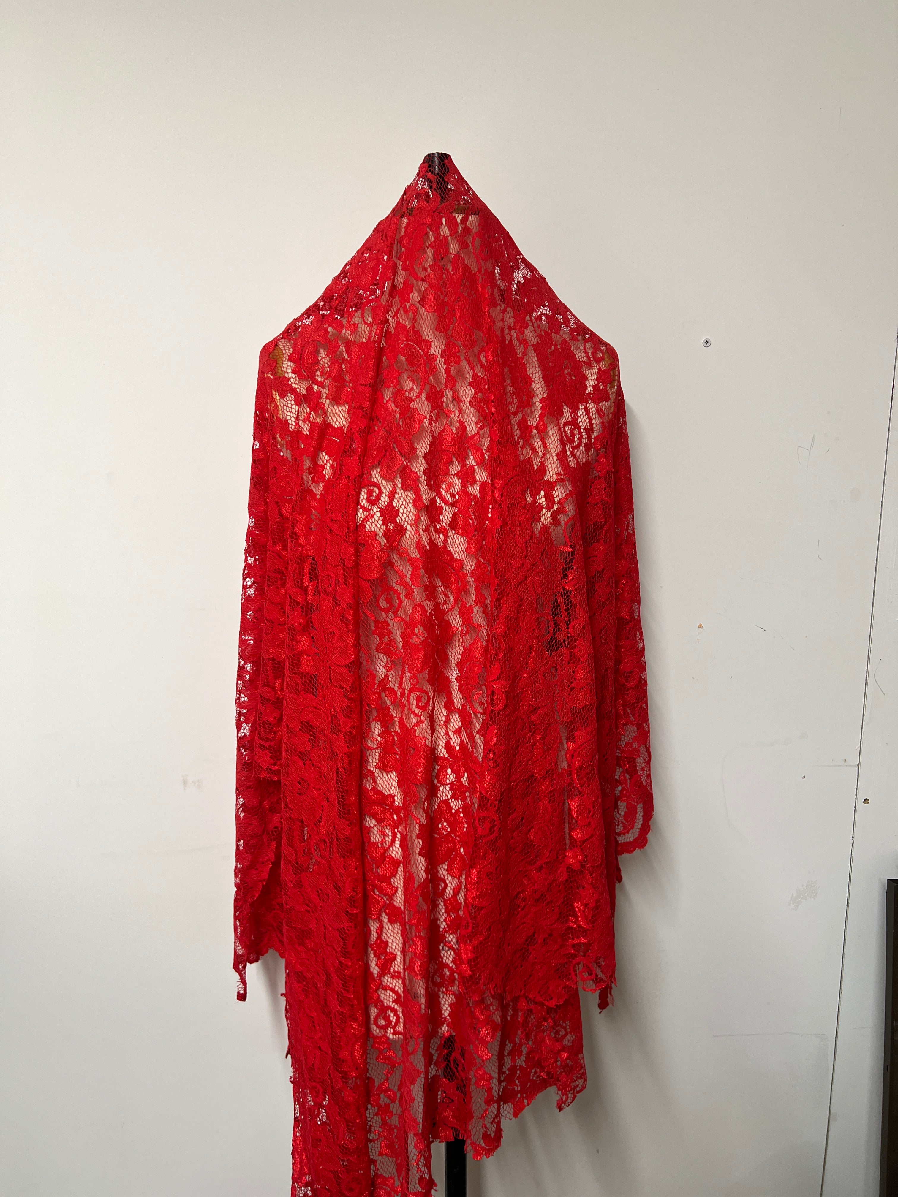 Red lace fabric on a white floor