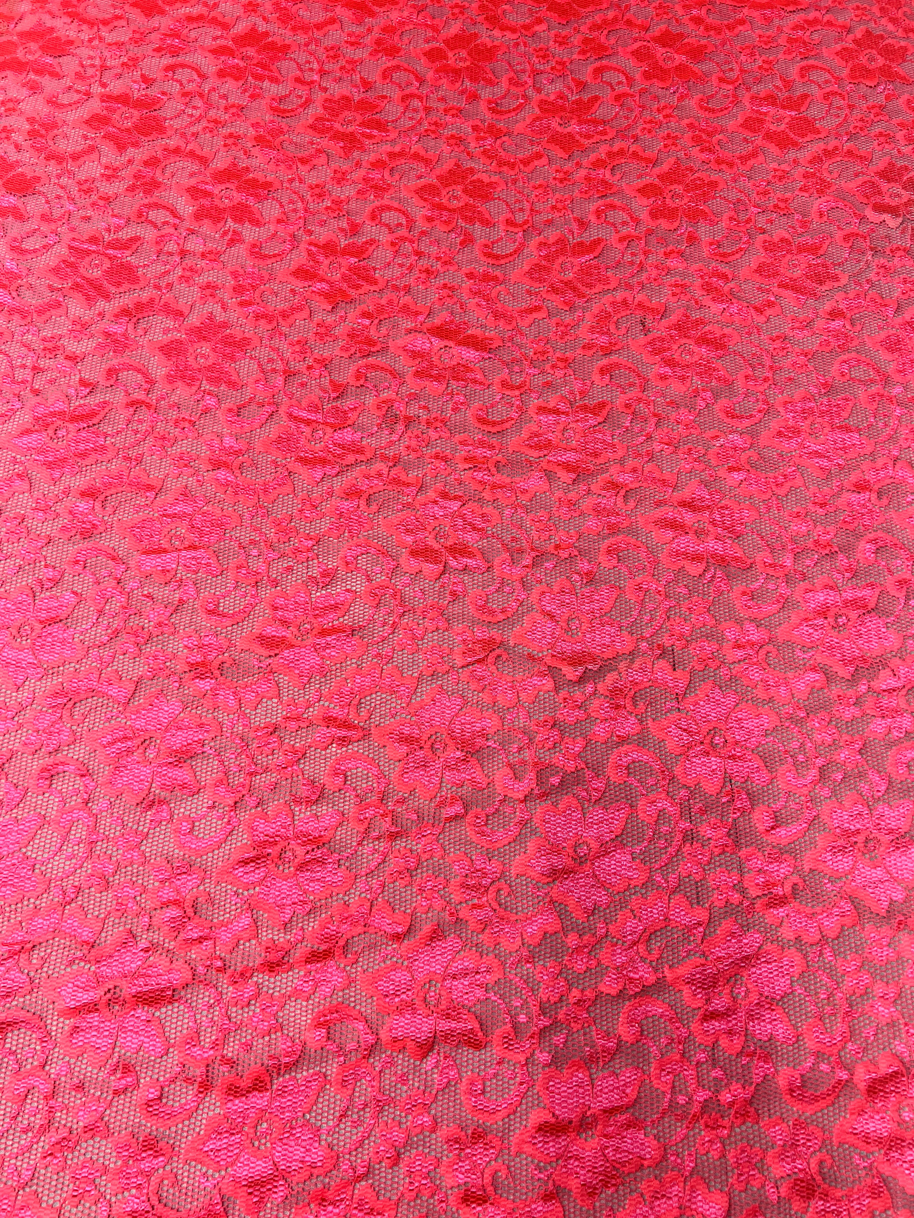 Close-up of red lace fabric with a floral pattern