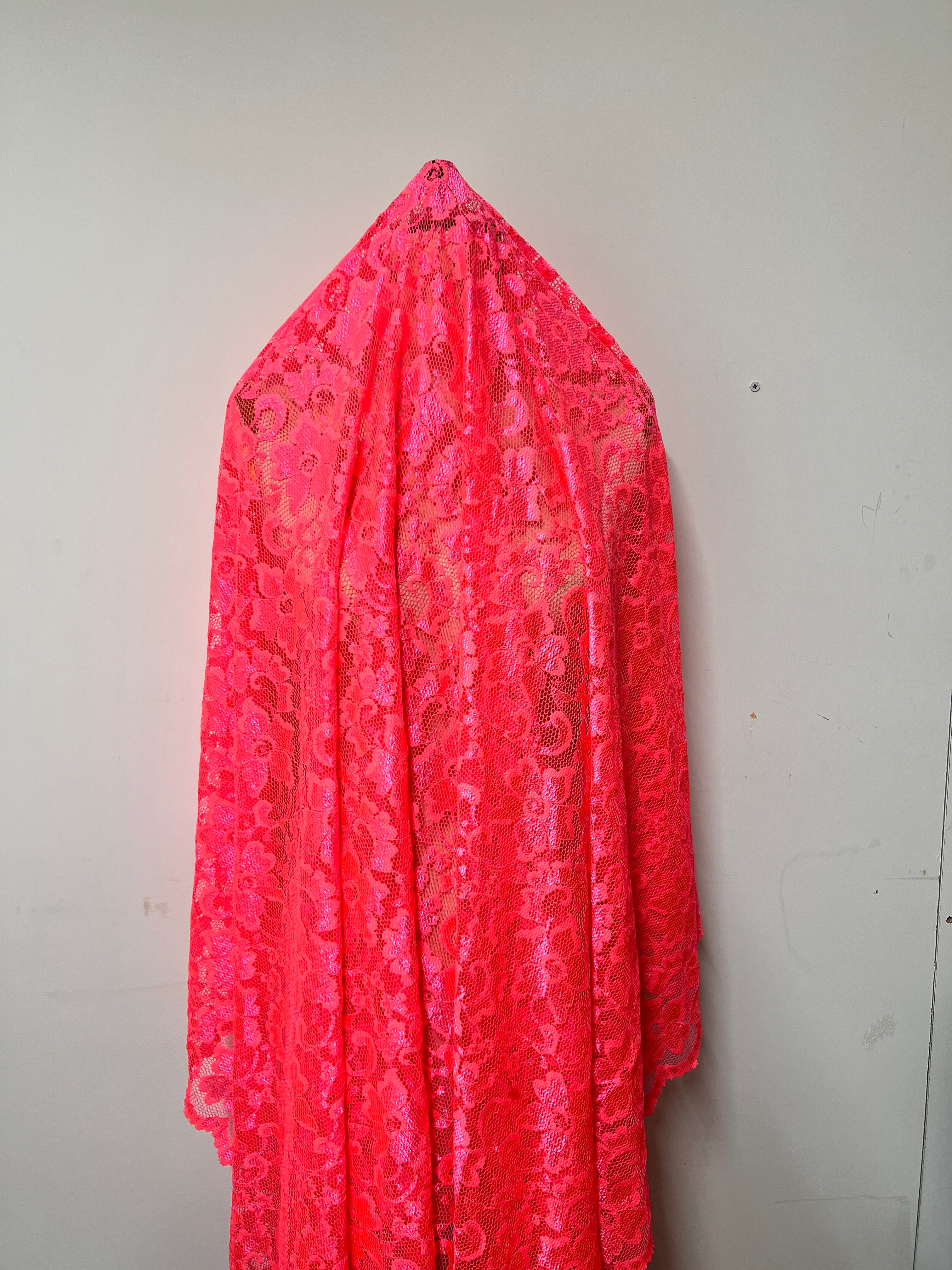 Pink lace fabric on a white background