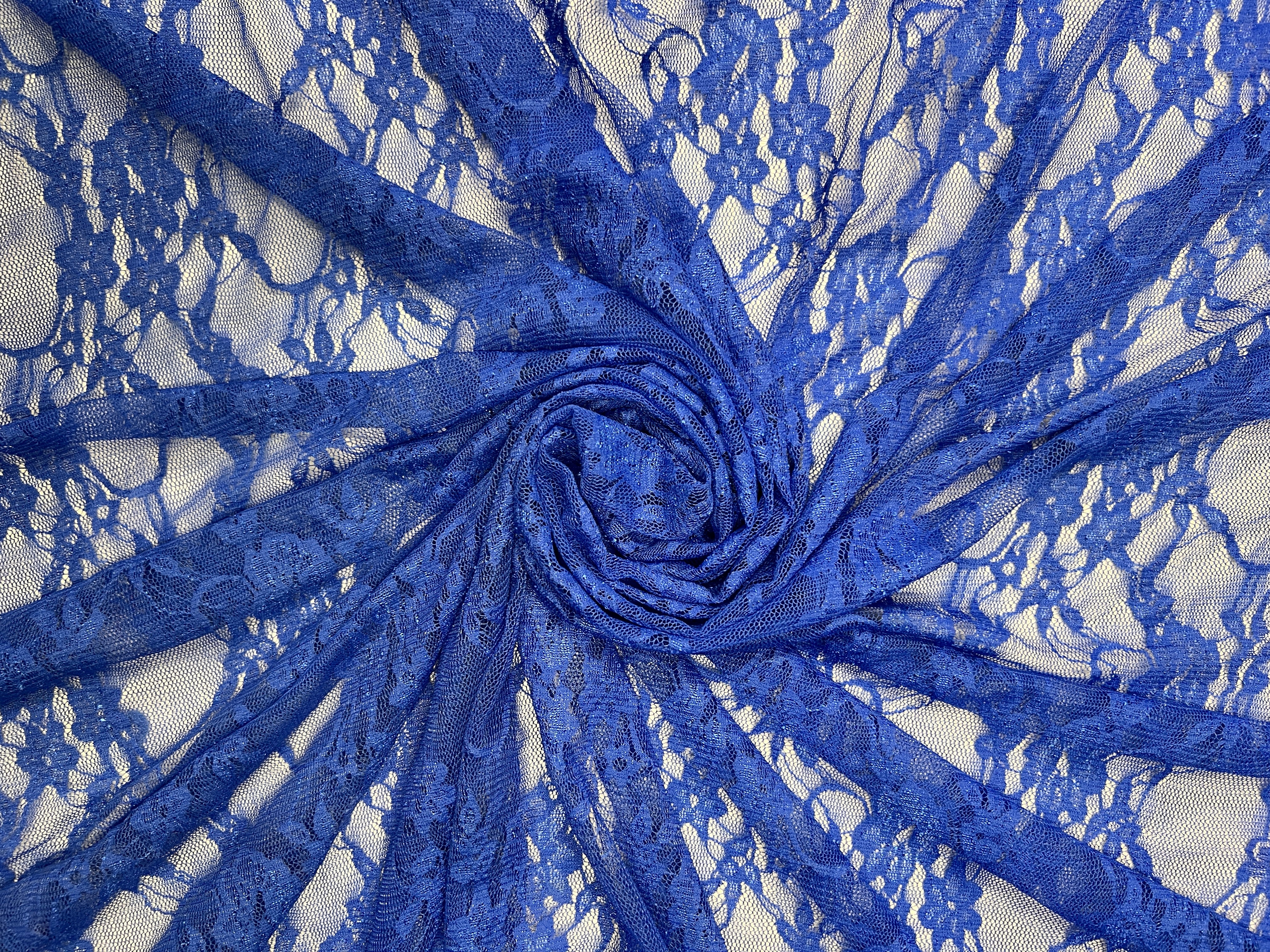 Close-up of blue lace fabric with a white background