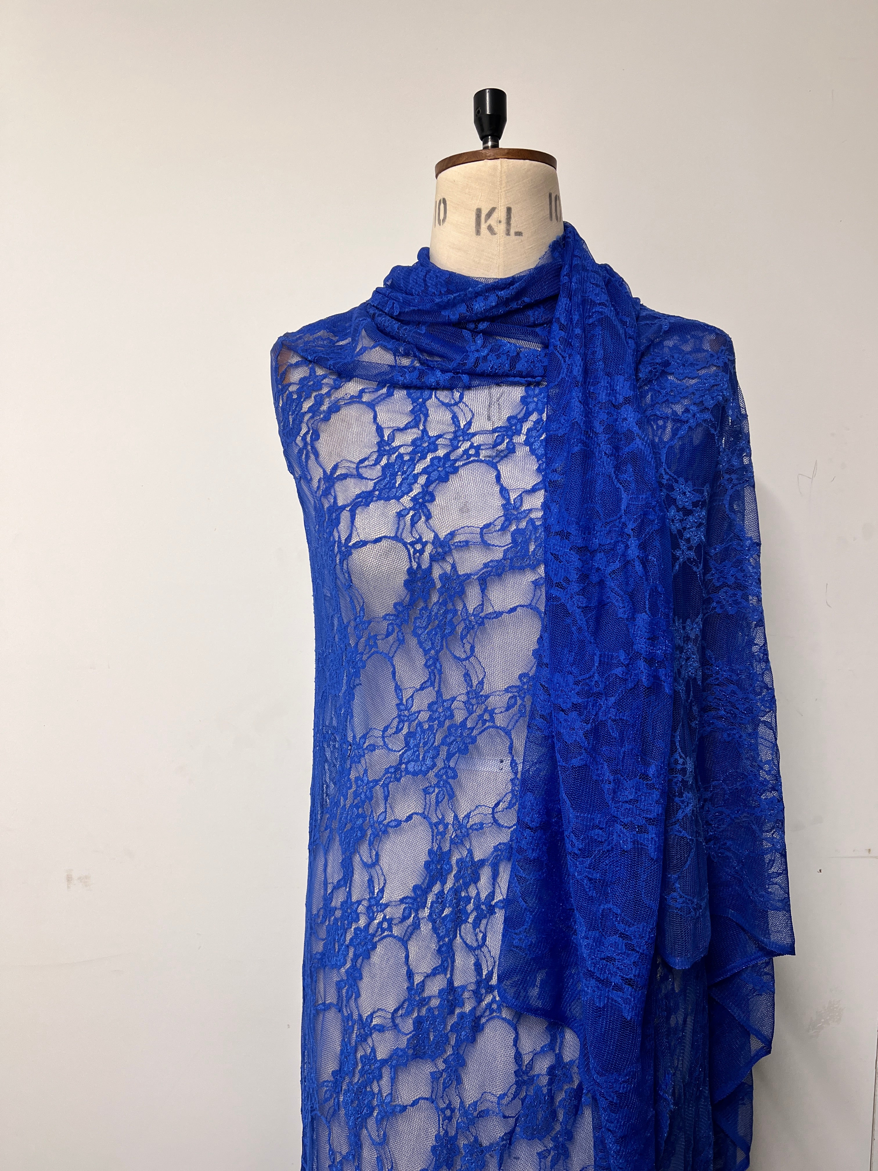 Blue lace fabric on a mannequin with a white background