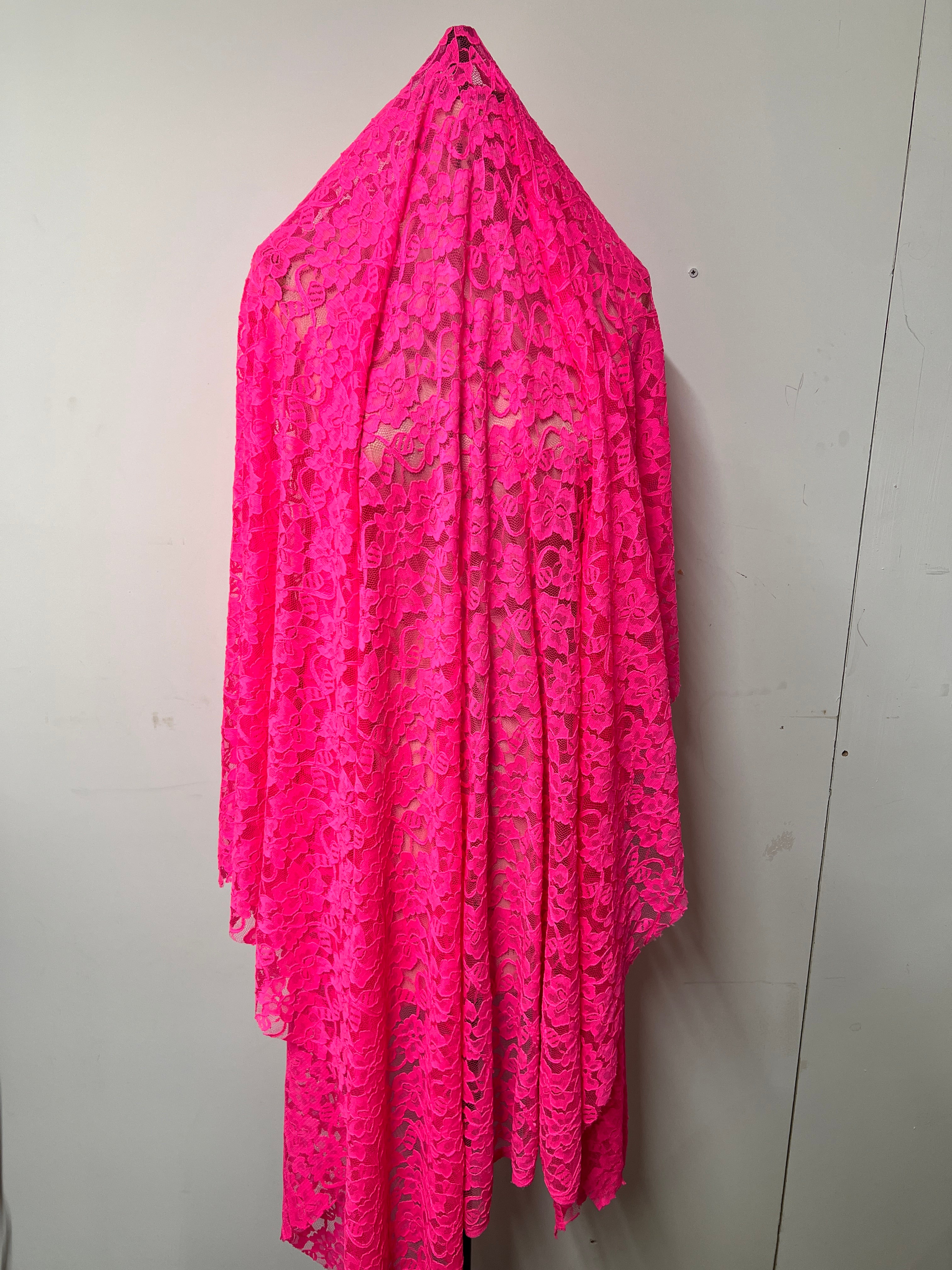 Pink lace fabric on a white background