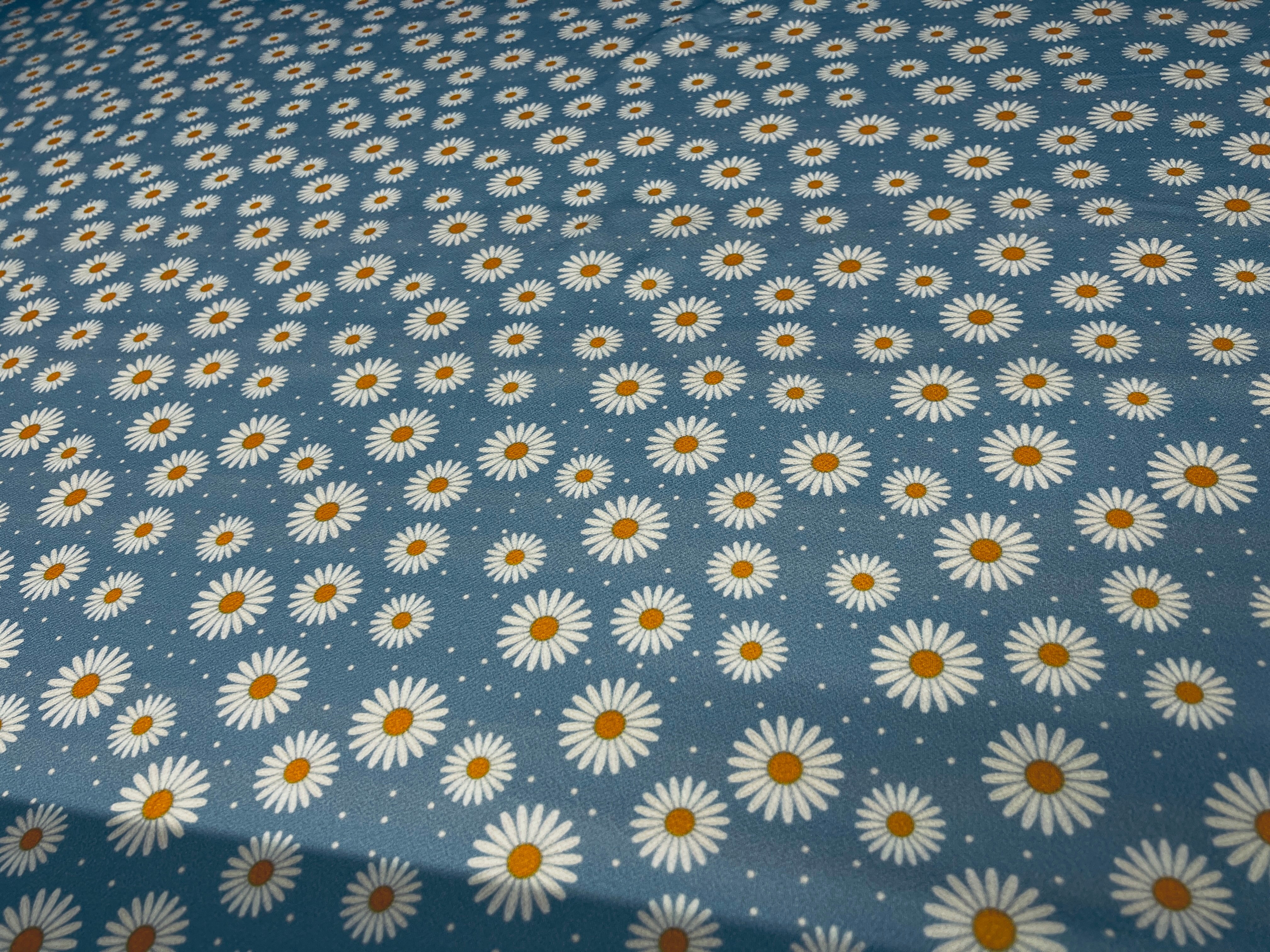 Playful blue daisy fabric, ideal for trendy outfits.