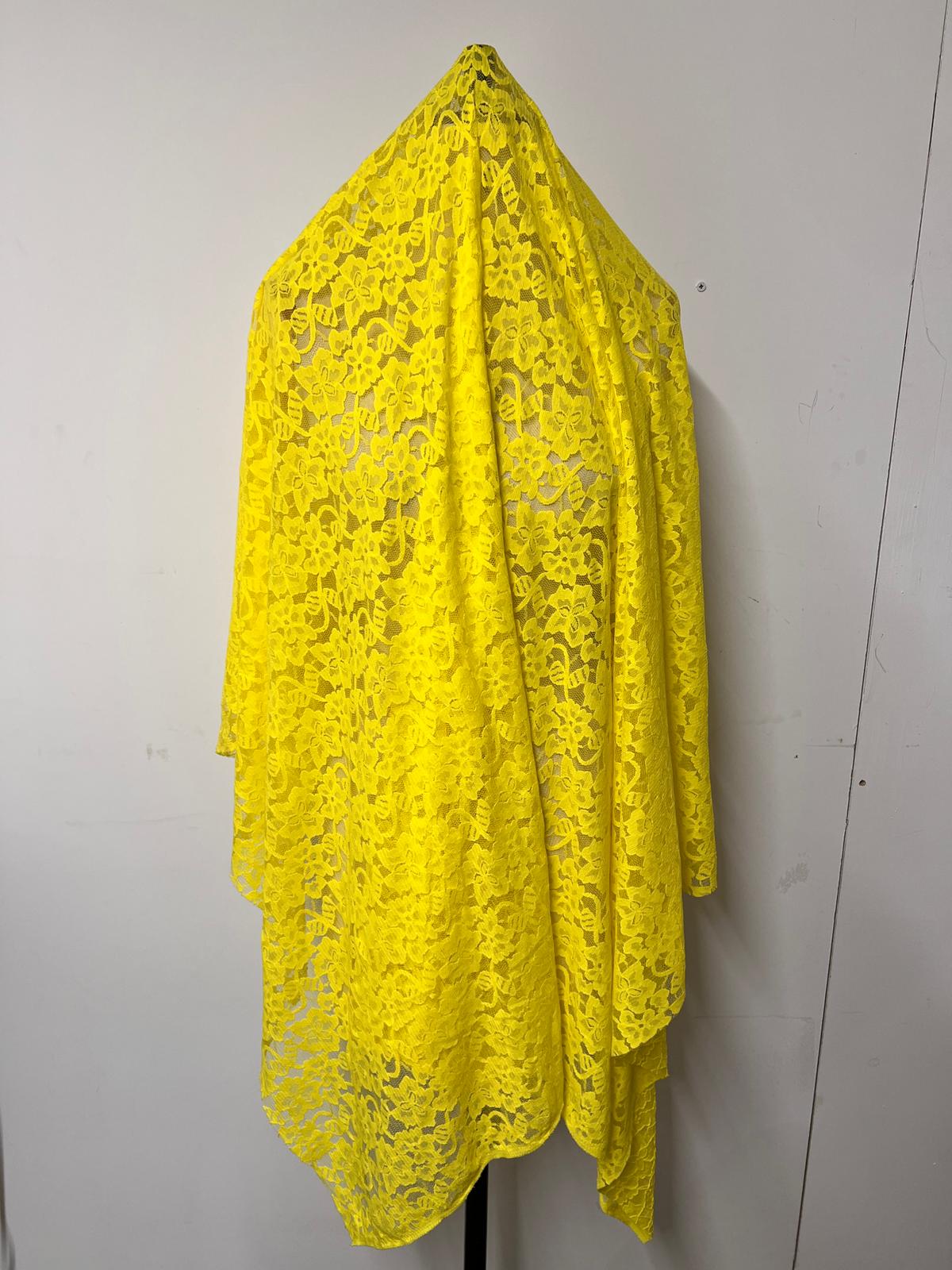 Yellow lace fabric draped over a white background