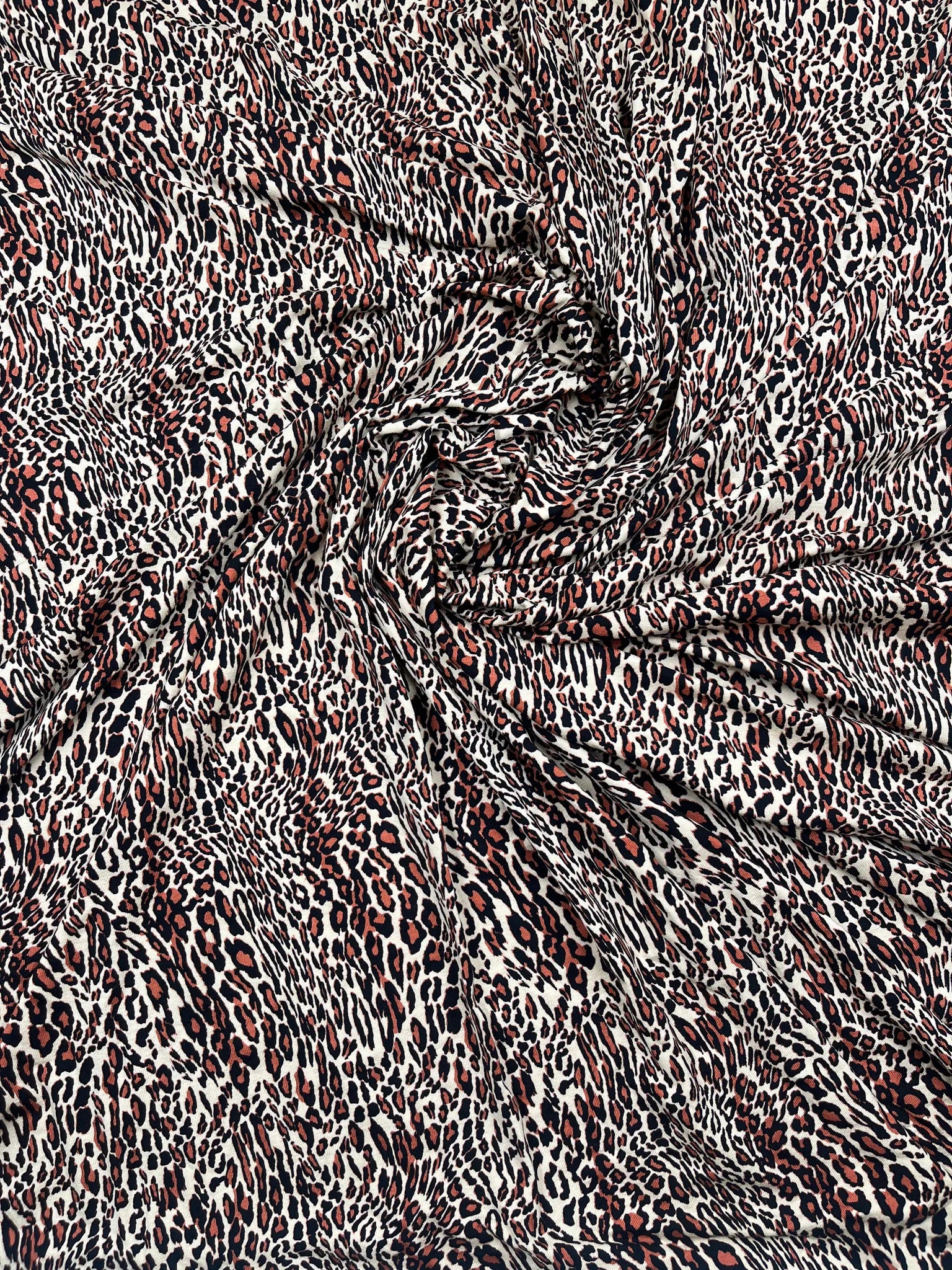 Flowing drape of animal print jersey fabric showcasing movement.