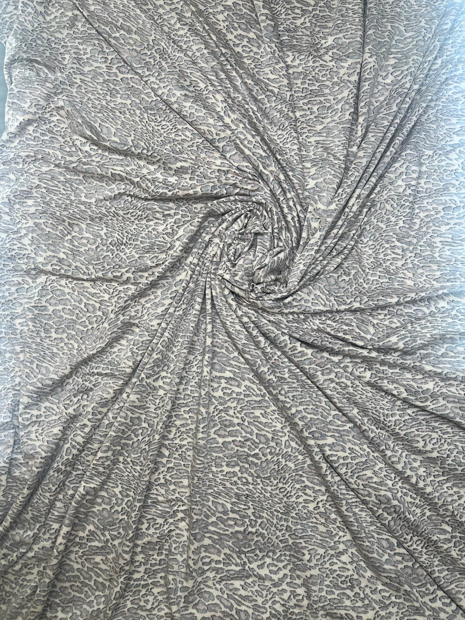 Cream, black, and rust animal print fabric draped elegantly.
