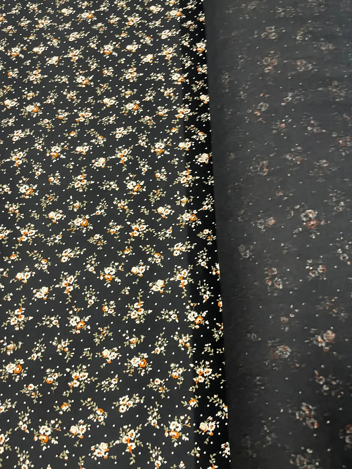 Close-up of black floral jersey fabric with ochre flowers