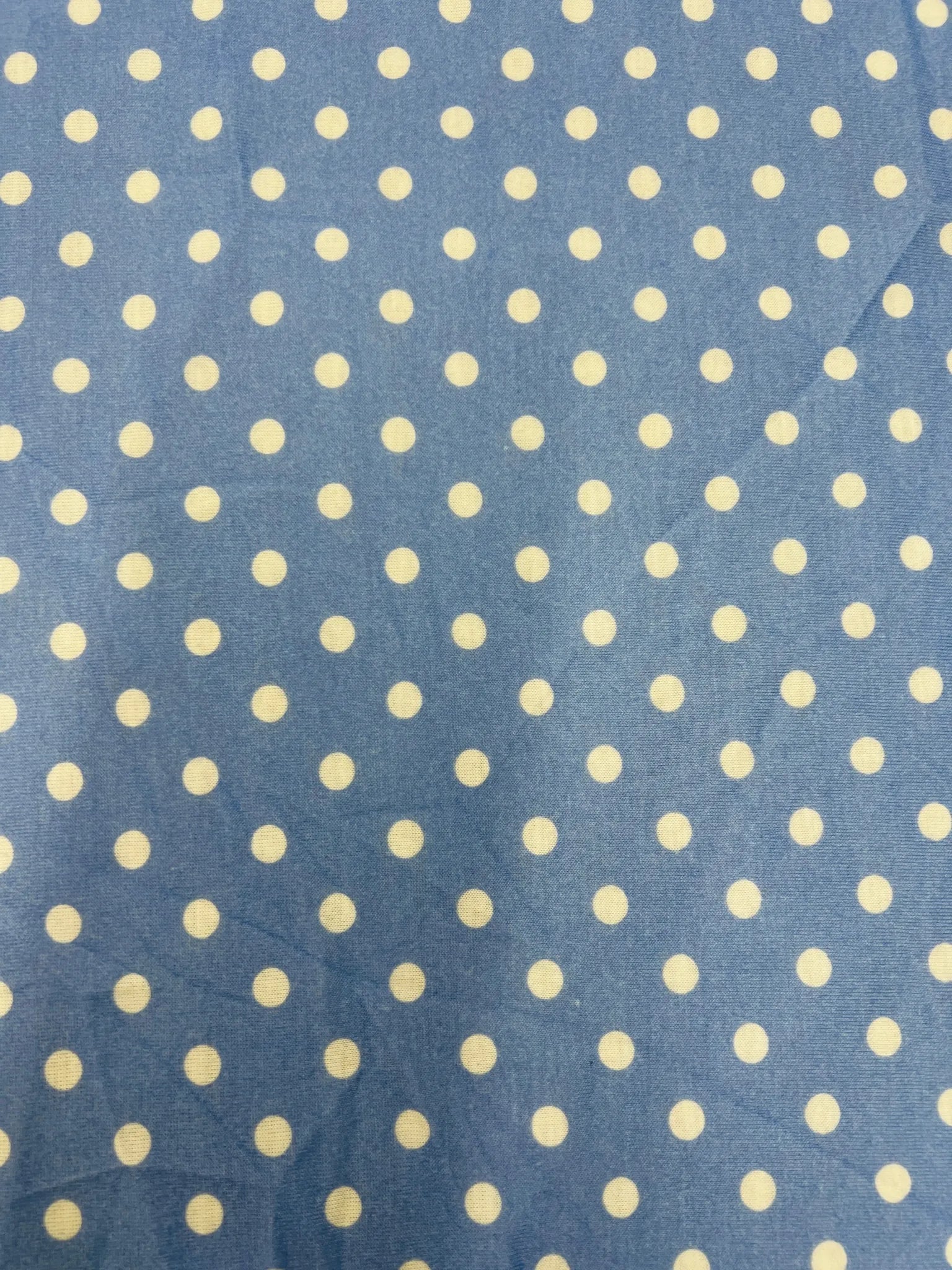 Blue polka dot fabric swatch with white spots