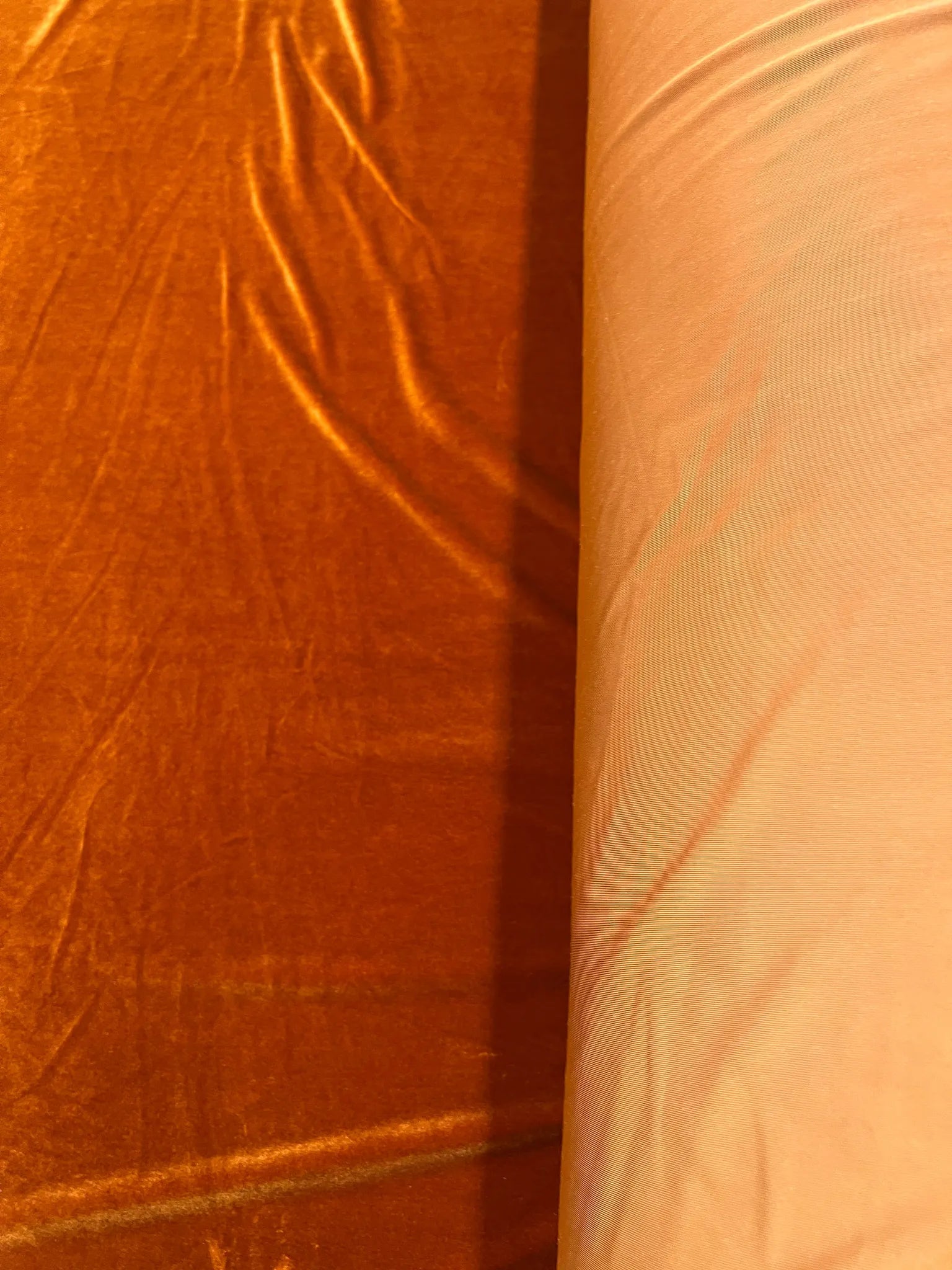 Soft plush texture of burnt orange velvet fabric ideal for costumes