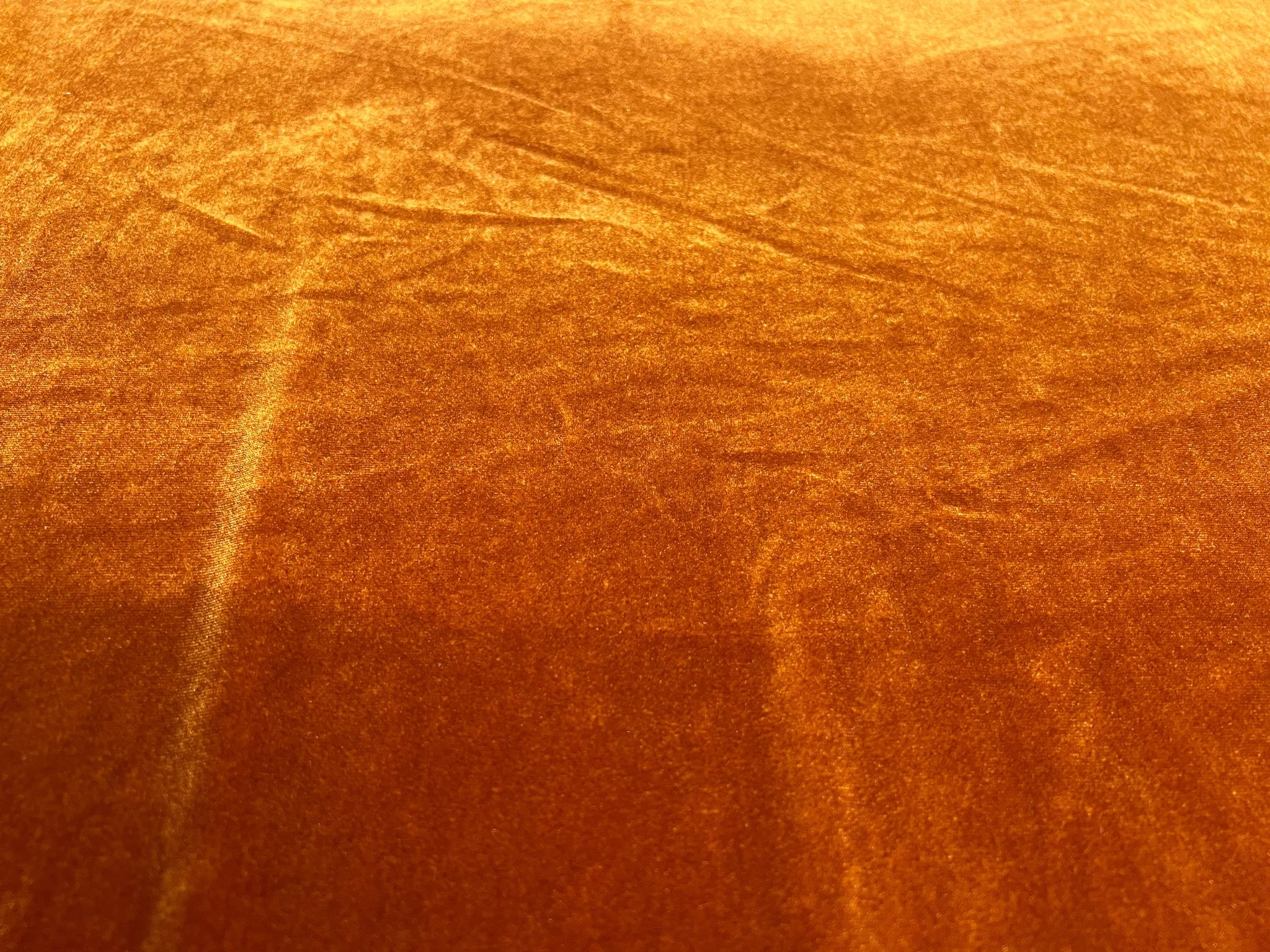 Close-up of luxurious burnt orange stretch velvet fabric