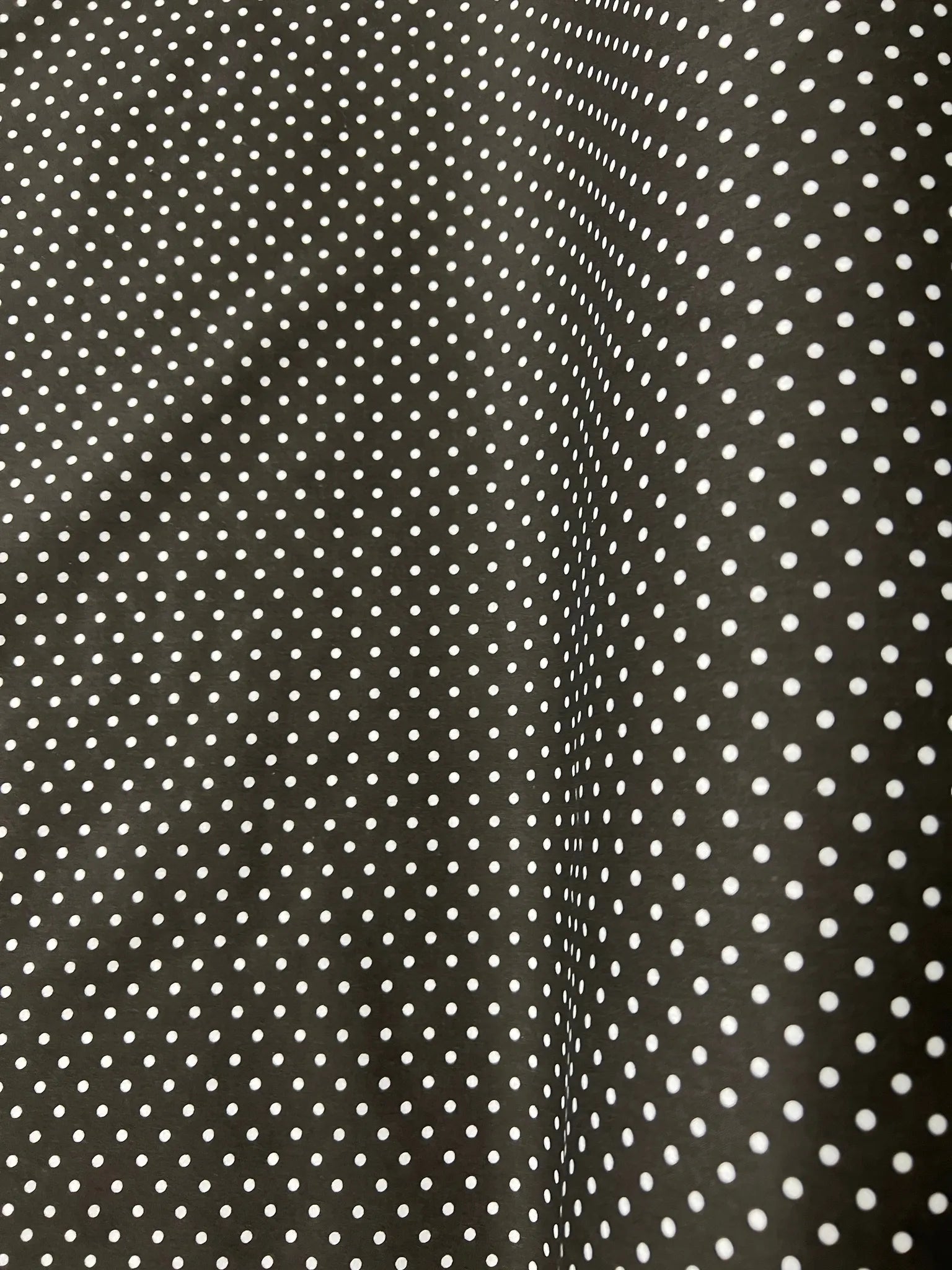 Close-up view of black and white polka dot cotton fabric texture