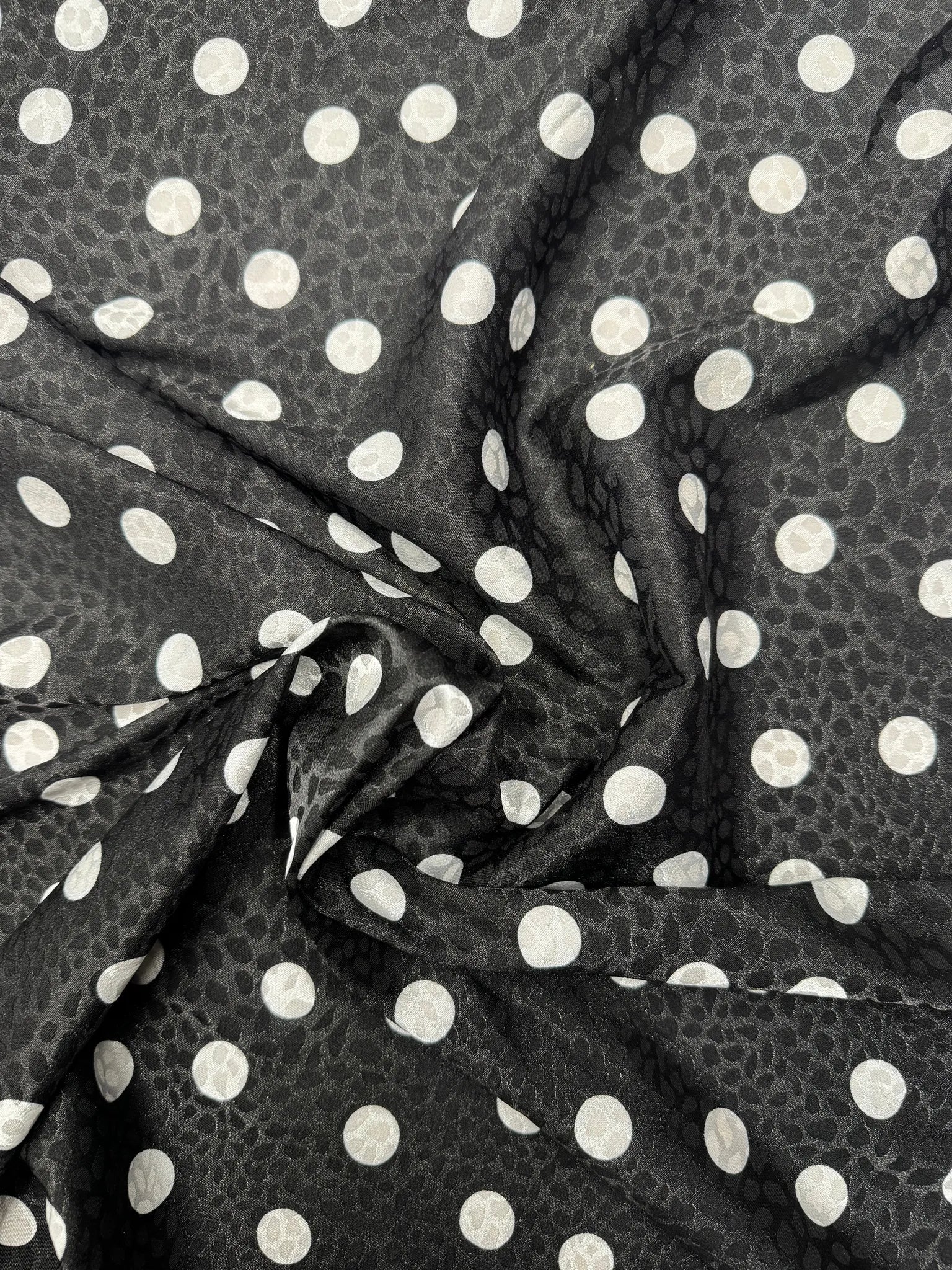 Wide view of luxurious black and white satin fabric