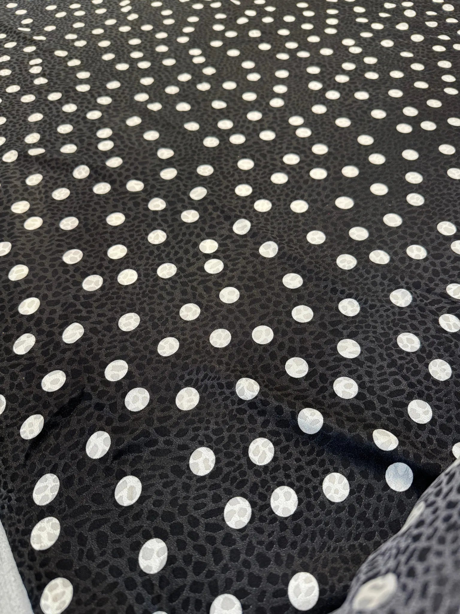 Draped black and white polka dot satin fabric