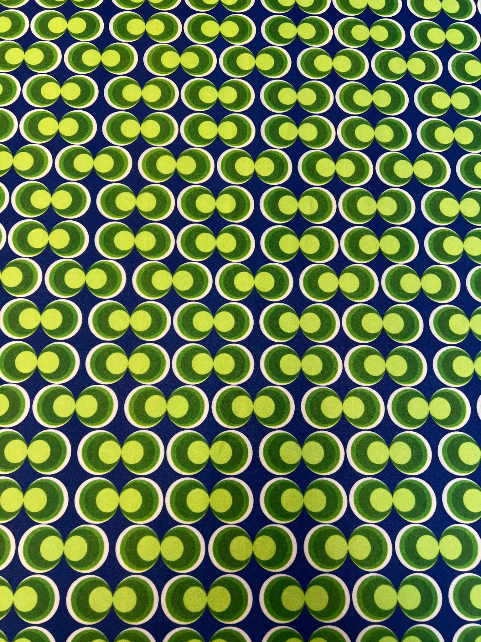 Smooth finish of blue and green geometric scuba crepe fabric