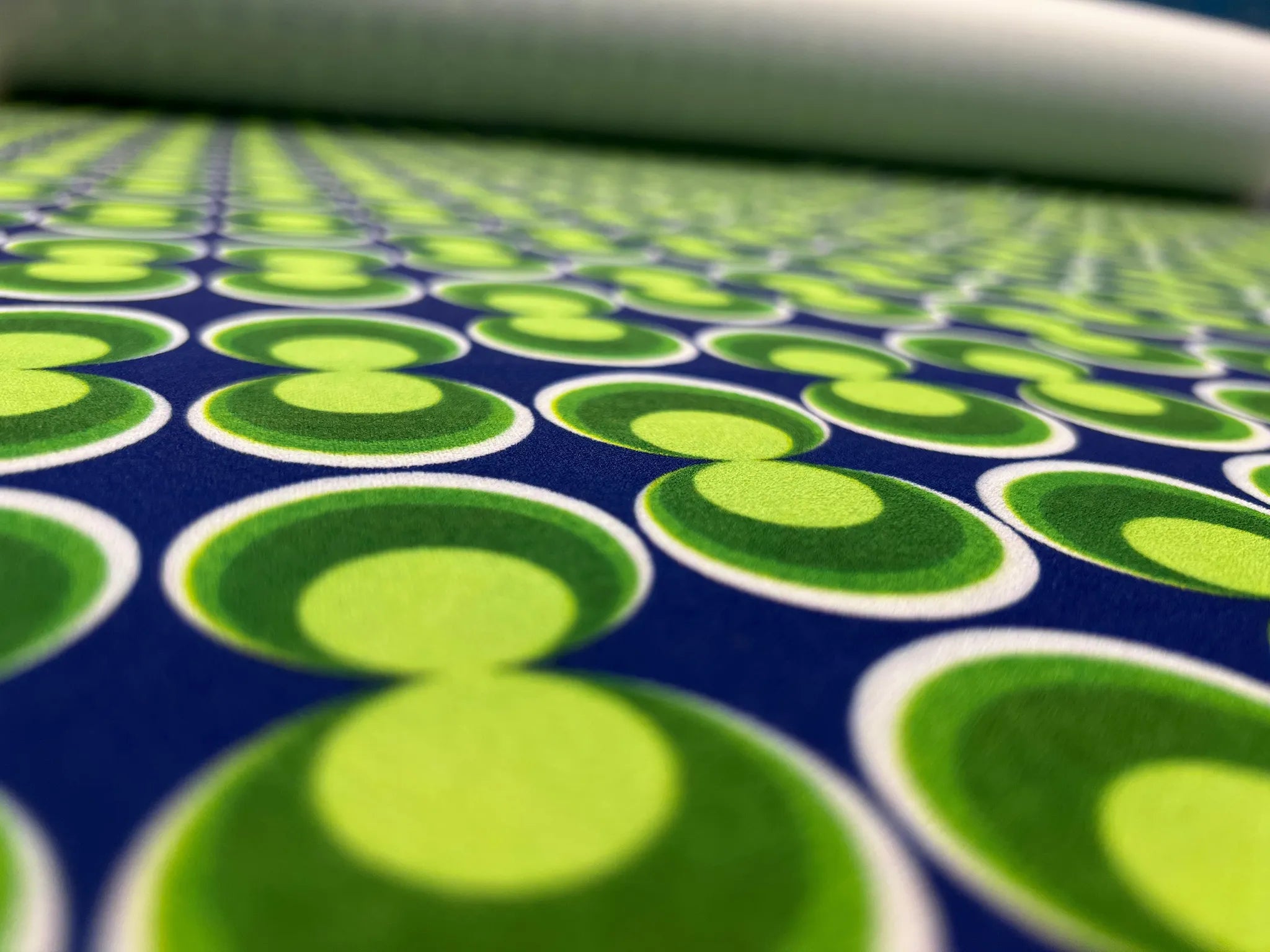 Roll of retro geometric scuba crepe fabric in blue and green