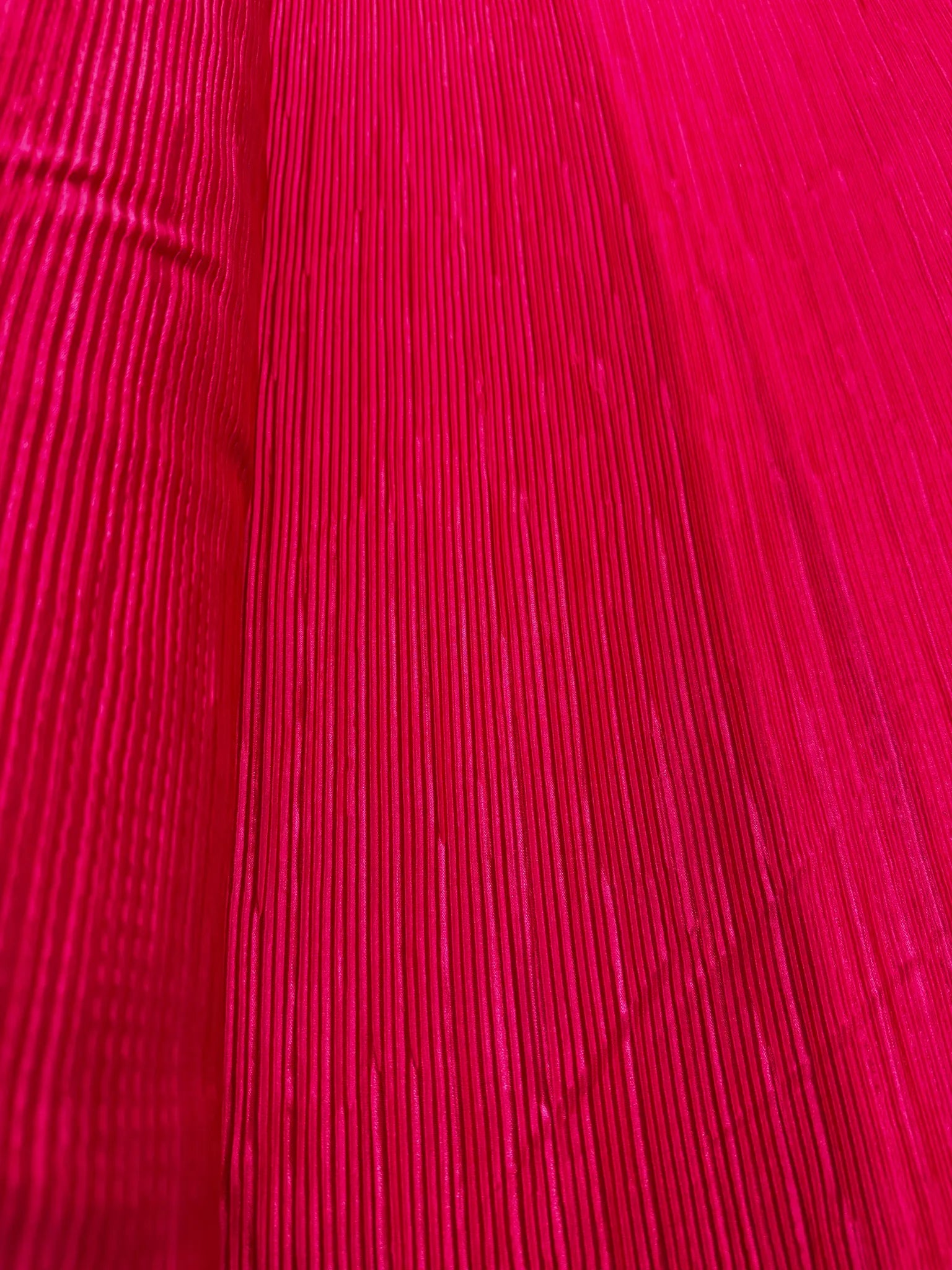 Flowing drape of lightweight hot pink plissé pleated fabric