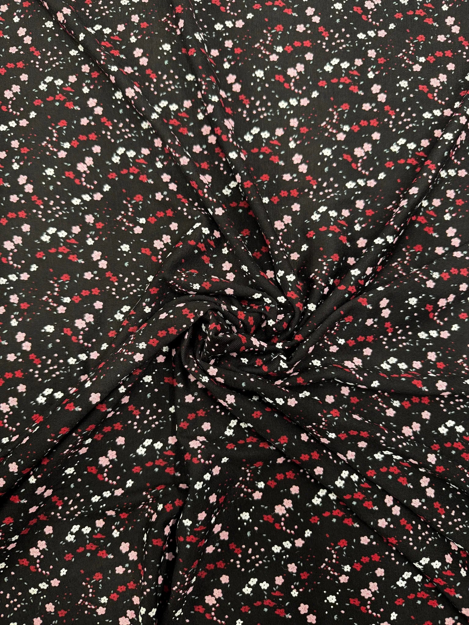 Black ditsy floral stretch jersey fabric with delicate blooms