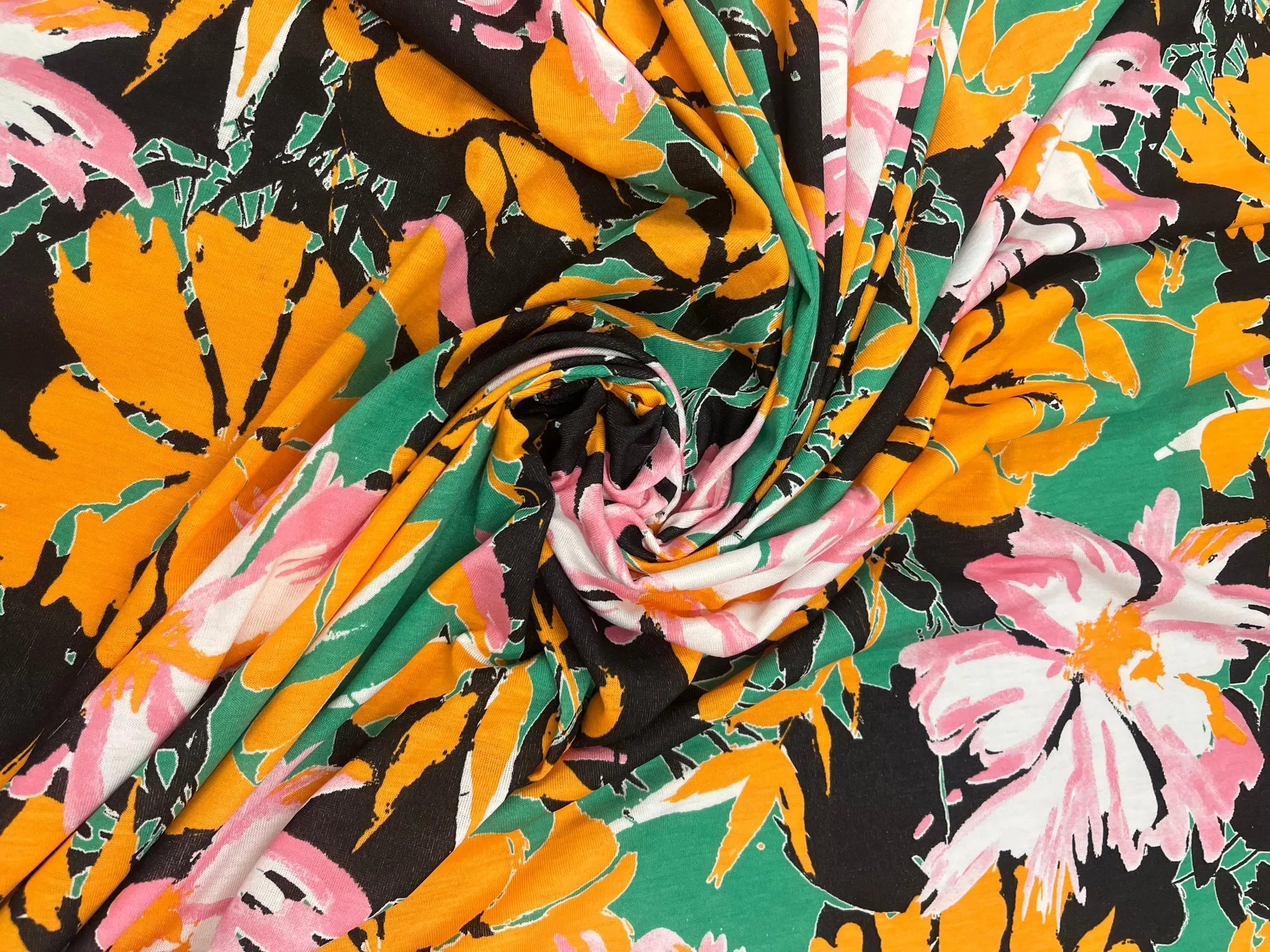 Vibrant green floral spun polyester jersey fabric with pink flowers
