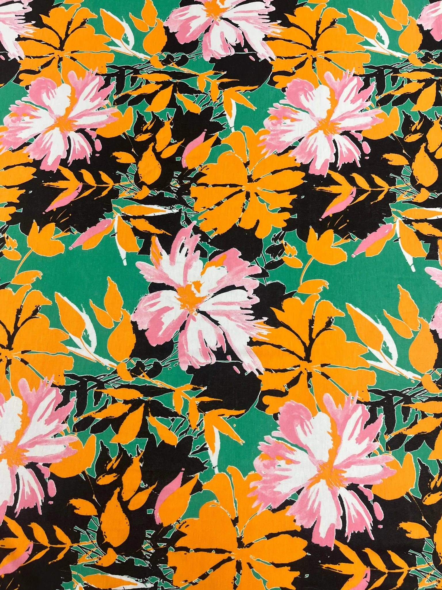 Close-up of vibrant green floral print on polyester fabric