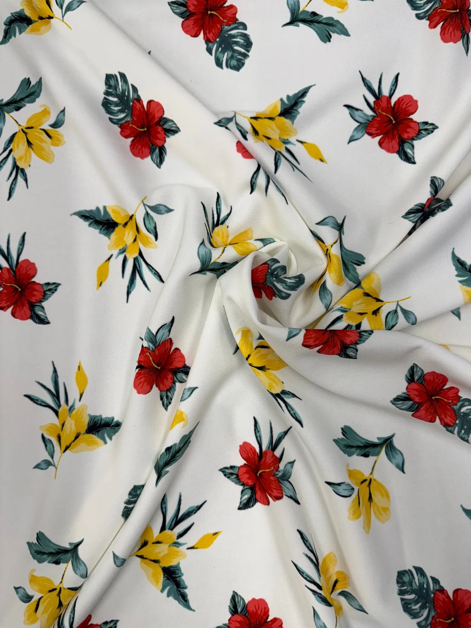Vibrant tropical floral fabric with red hibiscus and yellow flowers