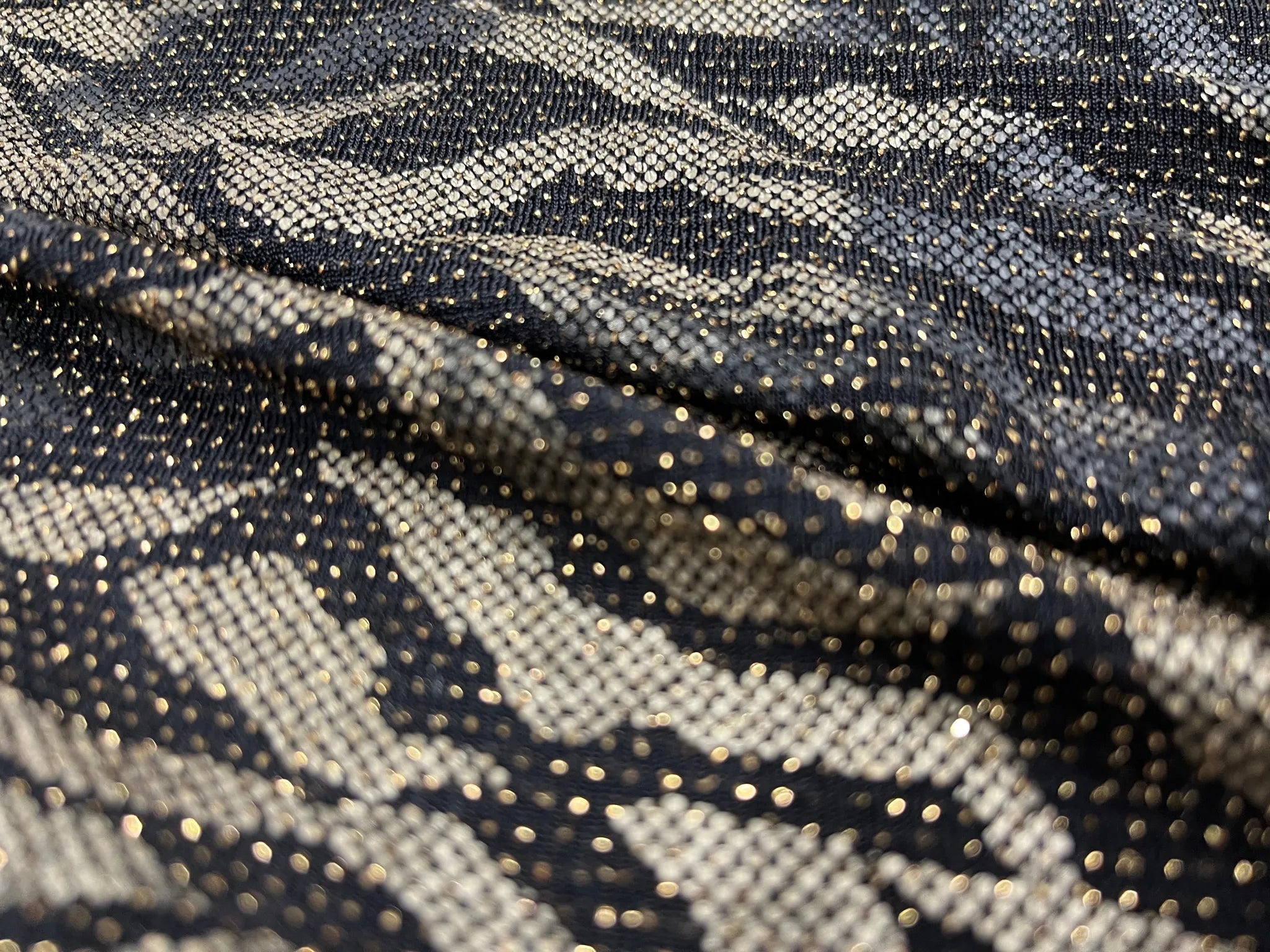 Close-up of shimmering black and gold zebra Lurex fabric