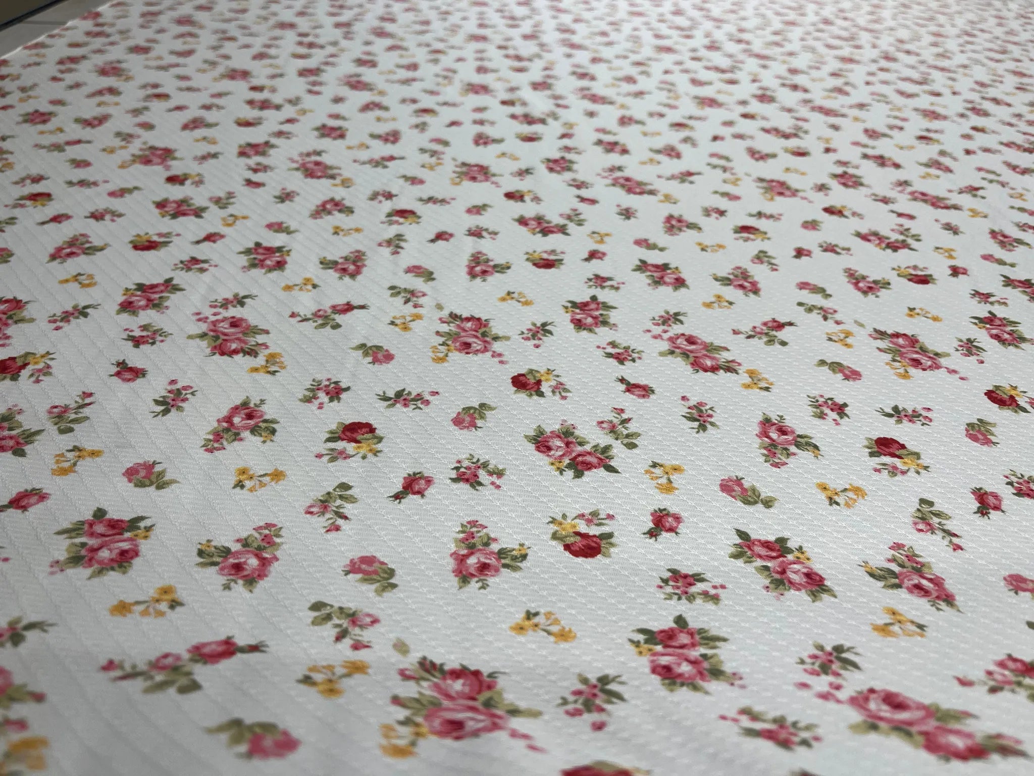 Vintage-inspired white fabric with delicate rose print