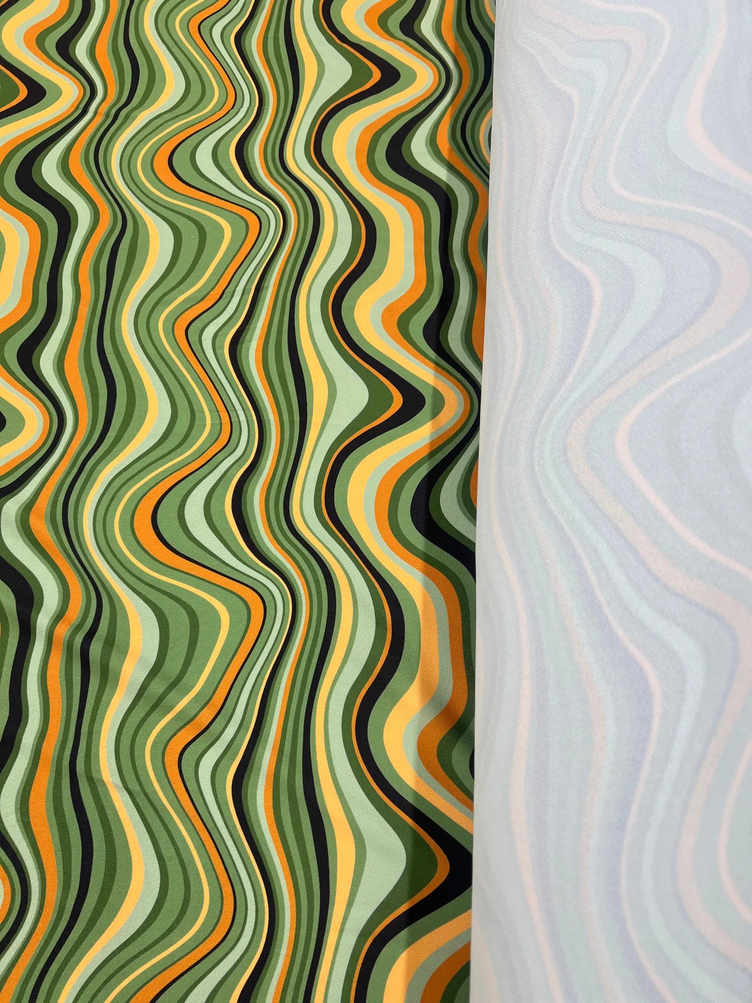 Close-up of Green Orange Black Swirl Jersey Crepe texture