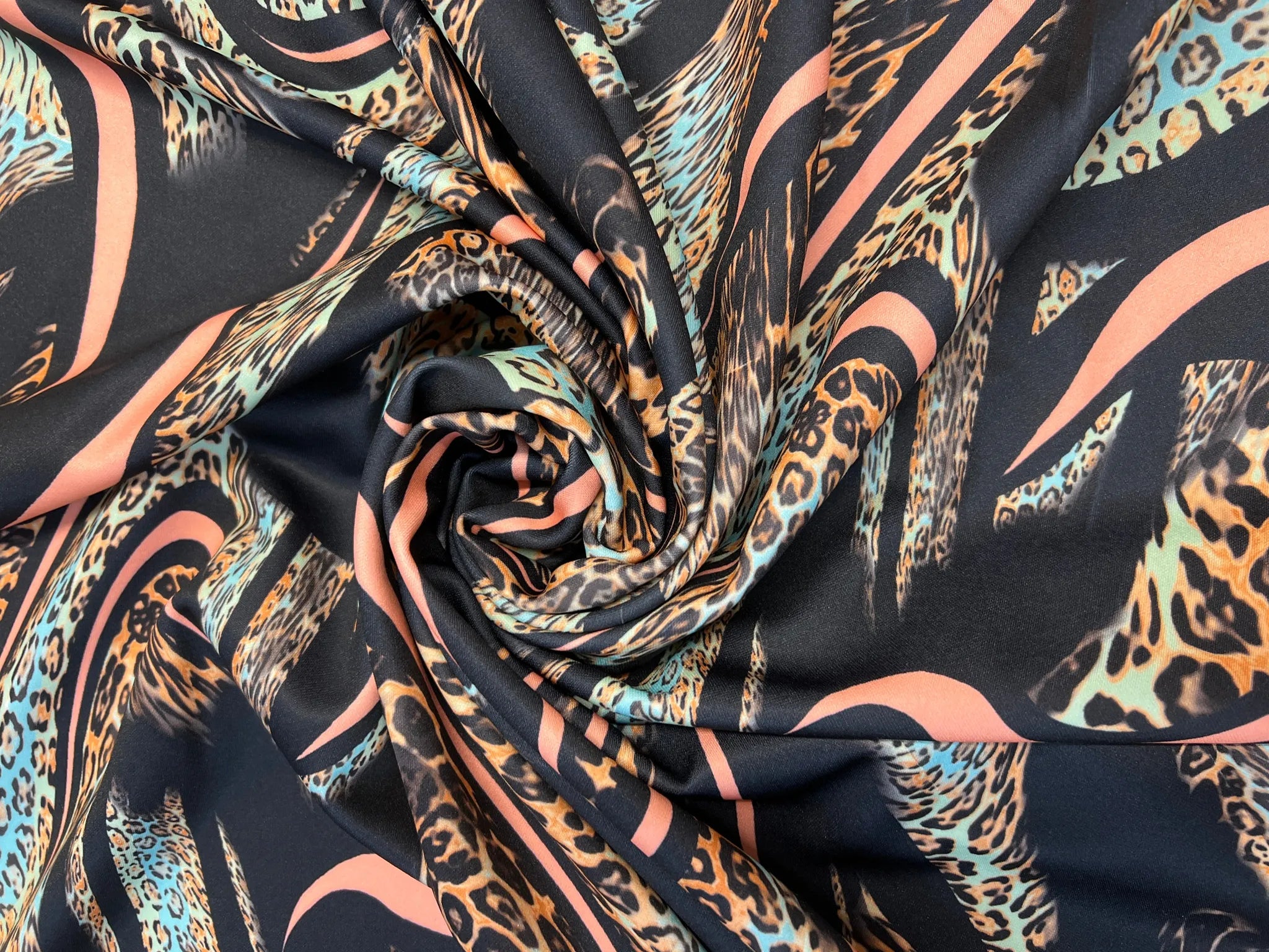 Fluid leopard print scuba fabric showcasing swirl design
