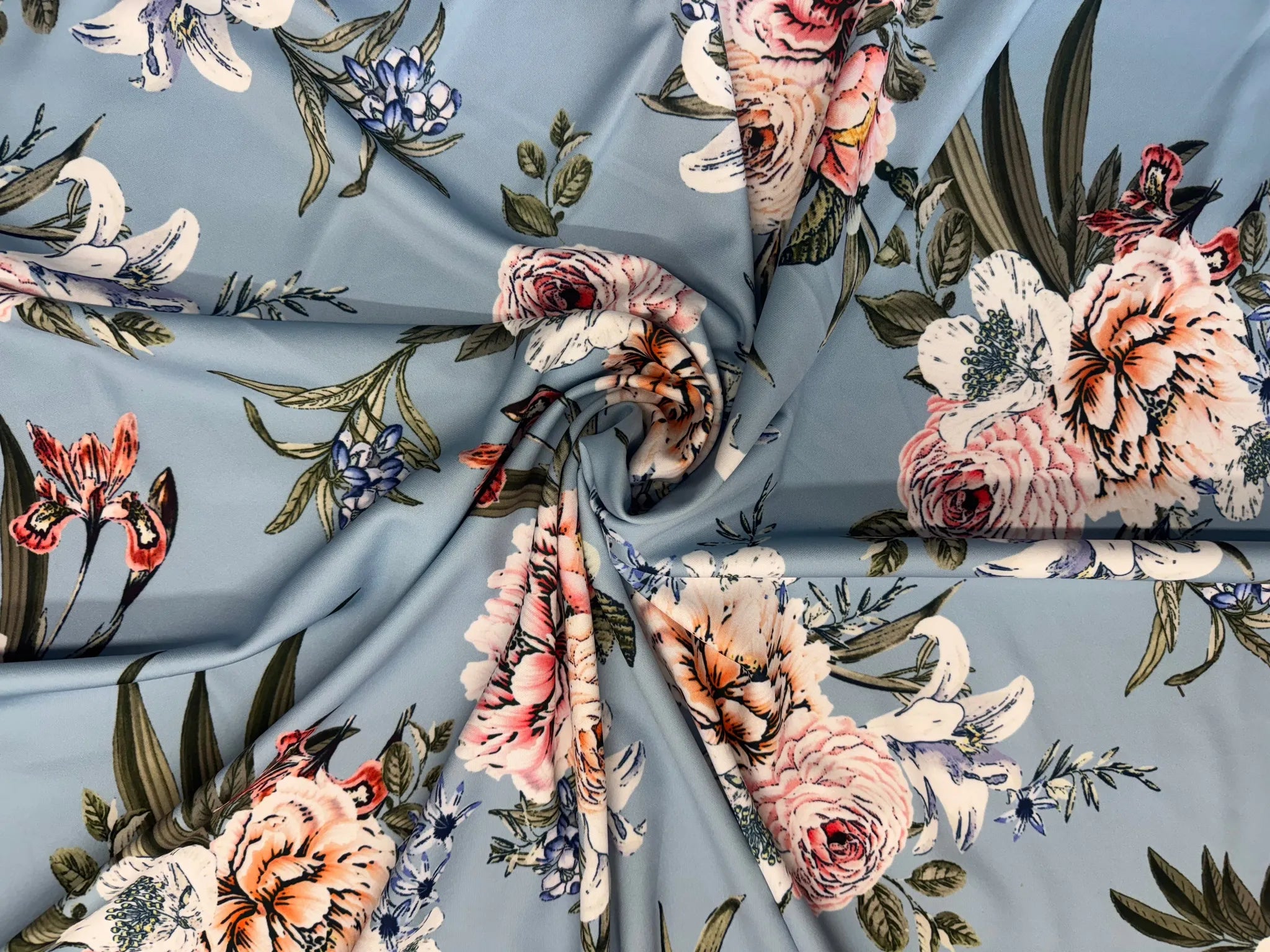 Dusty blue floral stretch scuba fabric on display