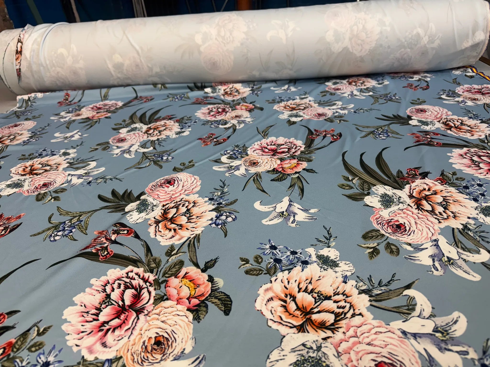 Roll of dusty blue floral stretch scuba fabric