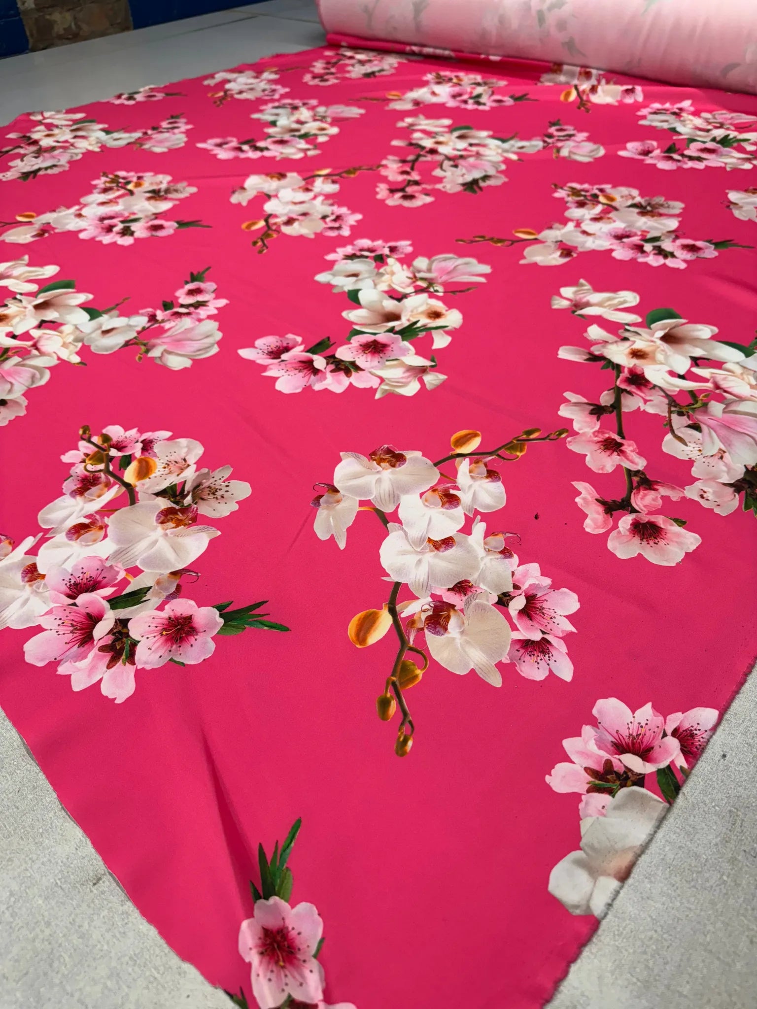 Draped hot pink floral print fabric highlighting its fluid texture