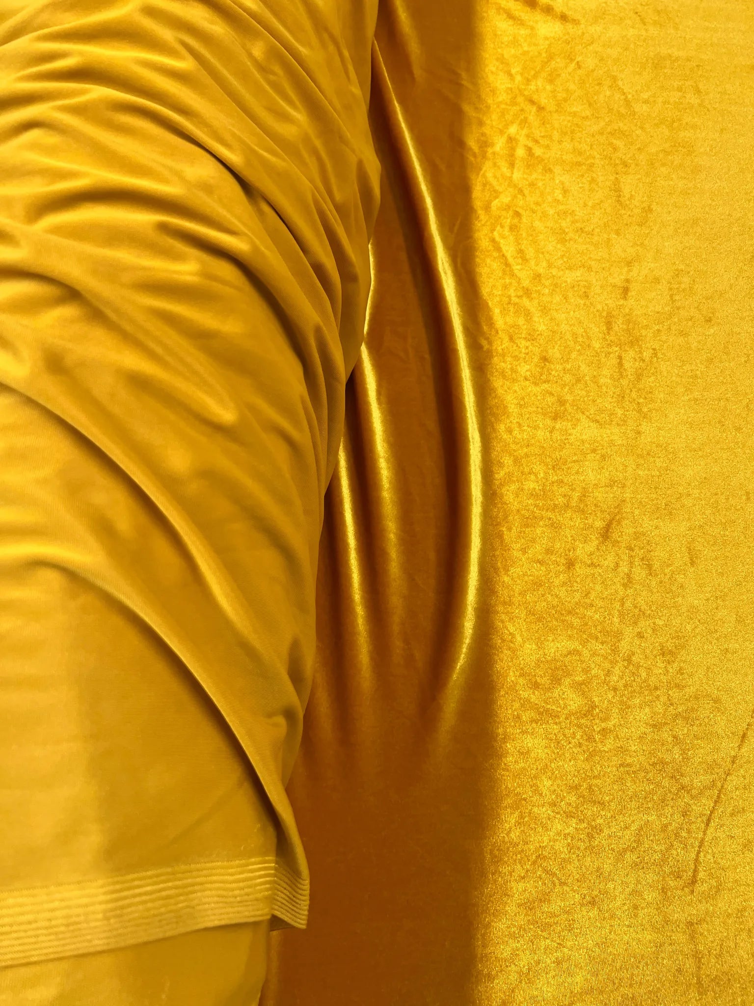 Close-up of soft gold stretch velvet fabric texture