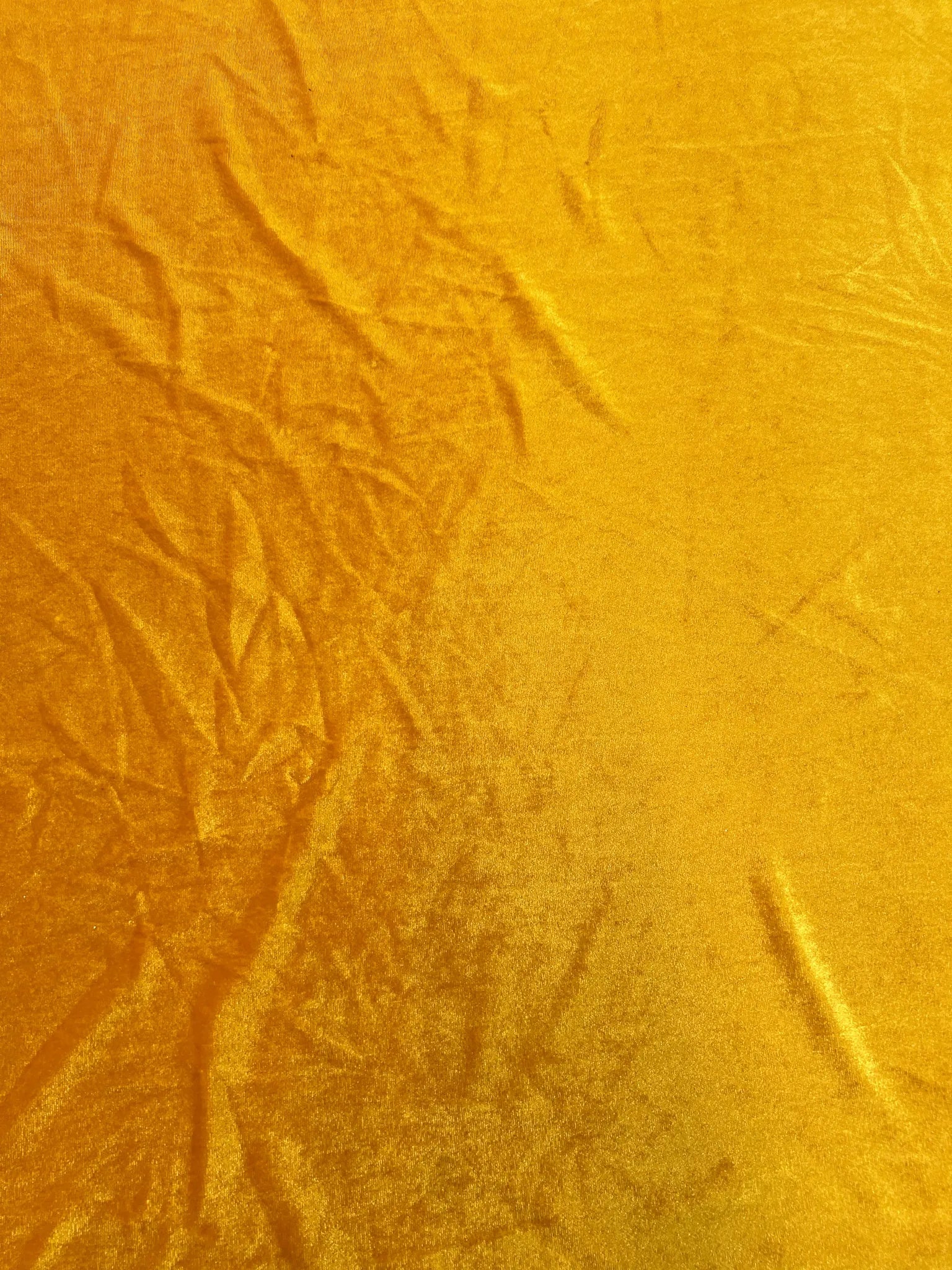 Gold stretch velvet fabric rolled for sewing projects