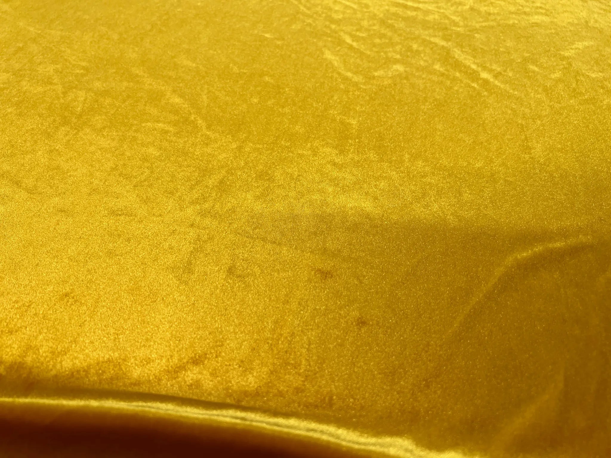 Beautiful gold stretch velvet fabric displayed flat