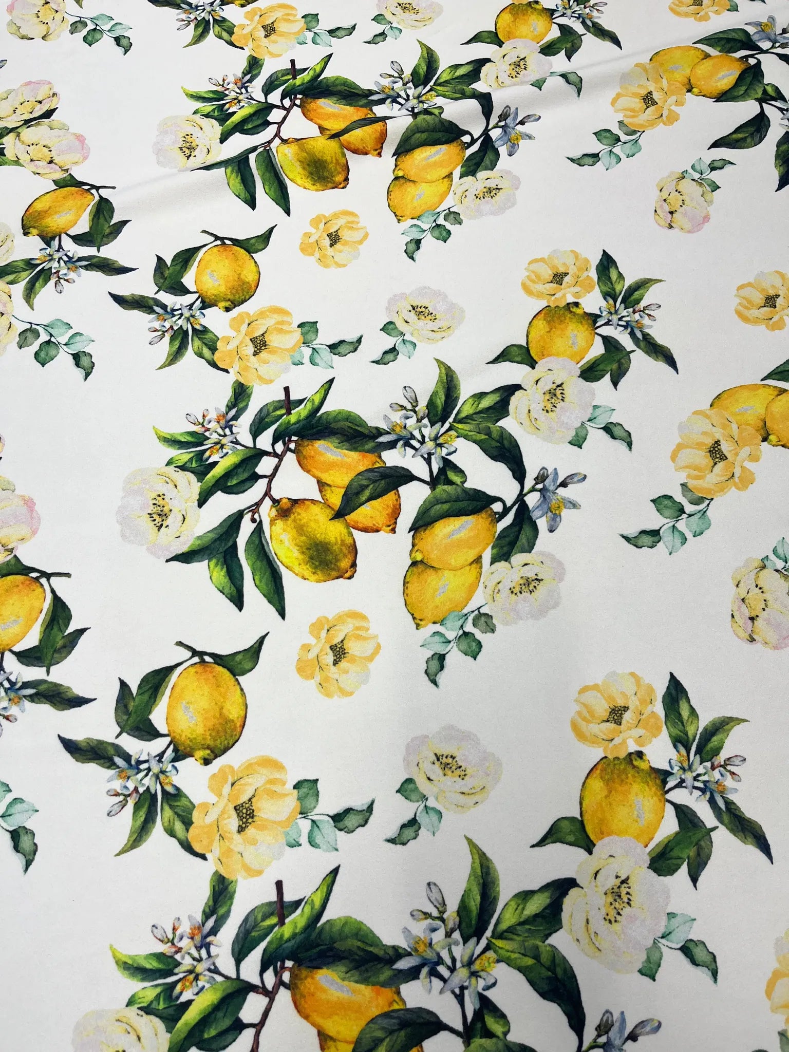 Floral details on white knit fabric with yellow lemons