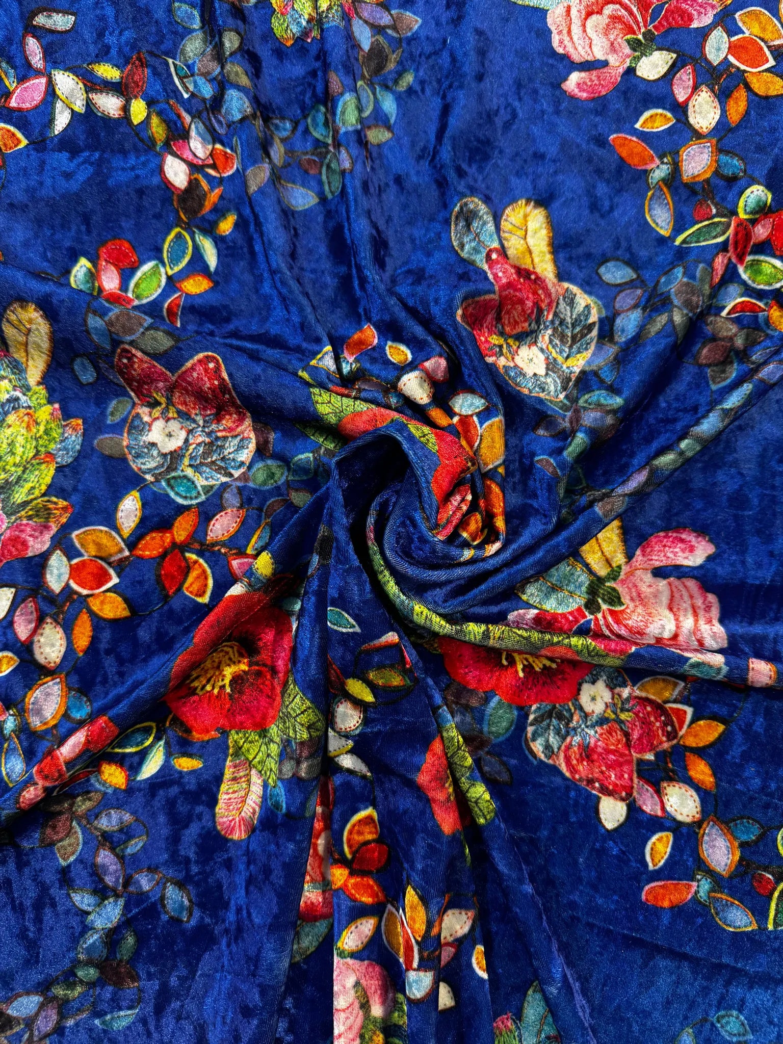 Royal blue floral crushed velvet fabric draped elegantly.