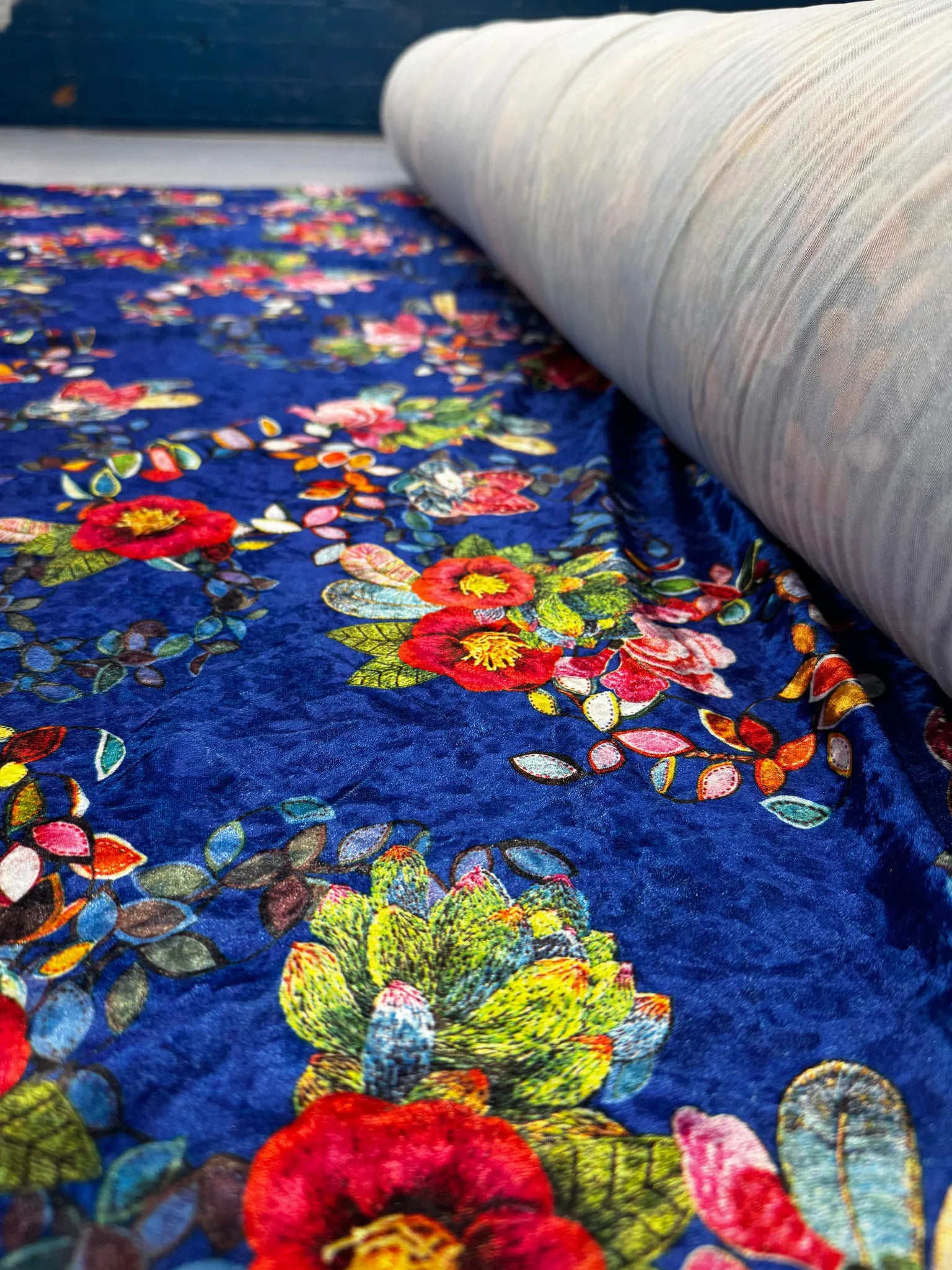 Close-up of multicolour botanical designs on velvet fabric.