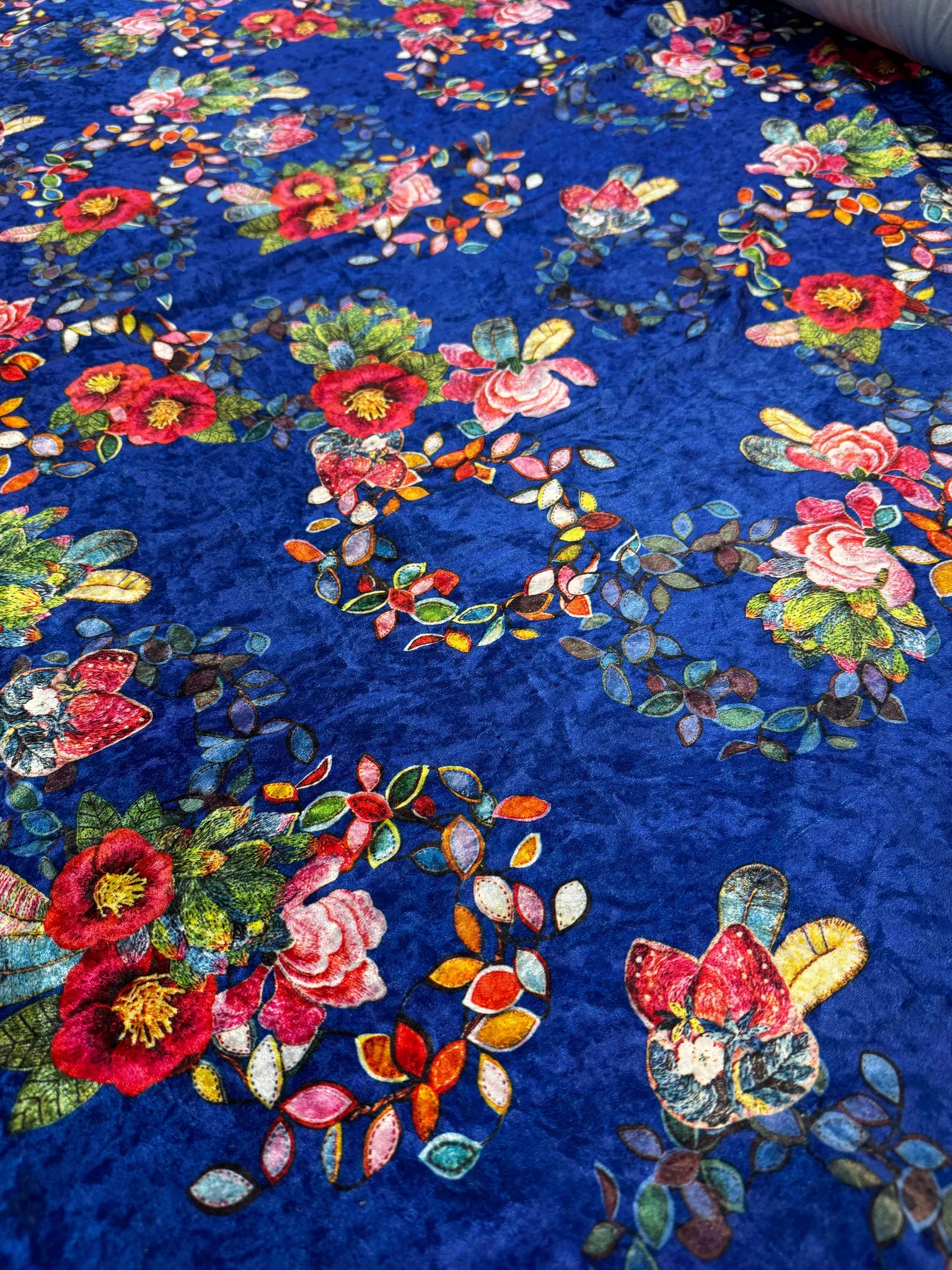 Luxury dress fabric in royal blue with vibrant botanical accents.