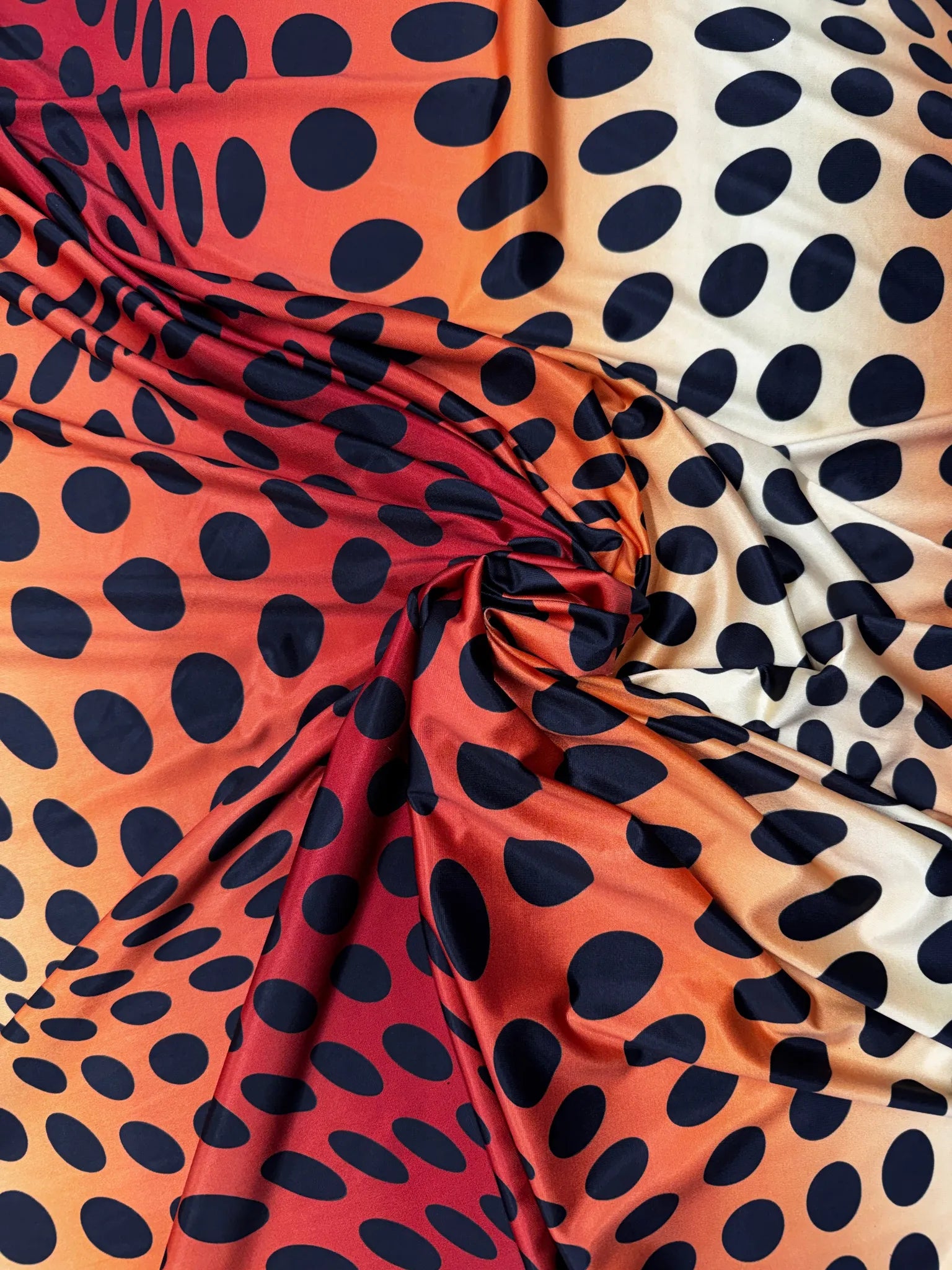 Red & Orange Sunset Ombré Polka Dot Slinky Jersey Fabric – black polka dots that grow and shrink over a red-to-orange ombré ground