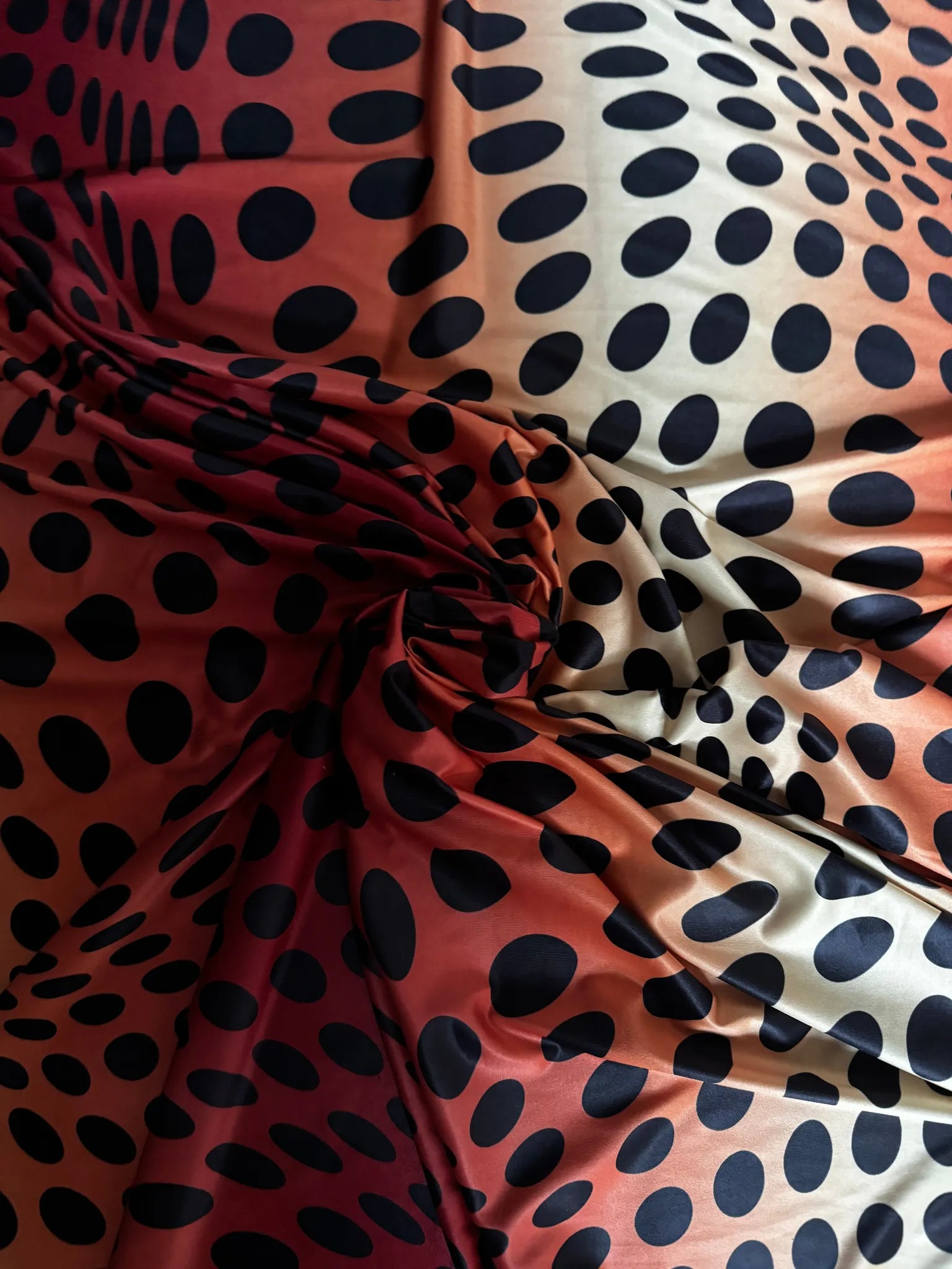 Red & Orange Sunset Ombré Polka Dot Slinky Jersey Fabric – swirled to show the drape and print