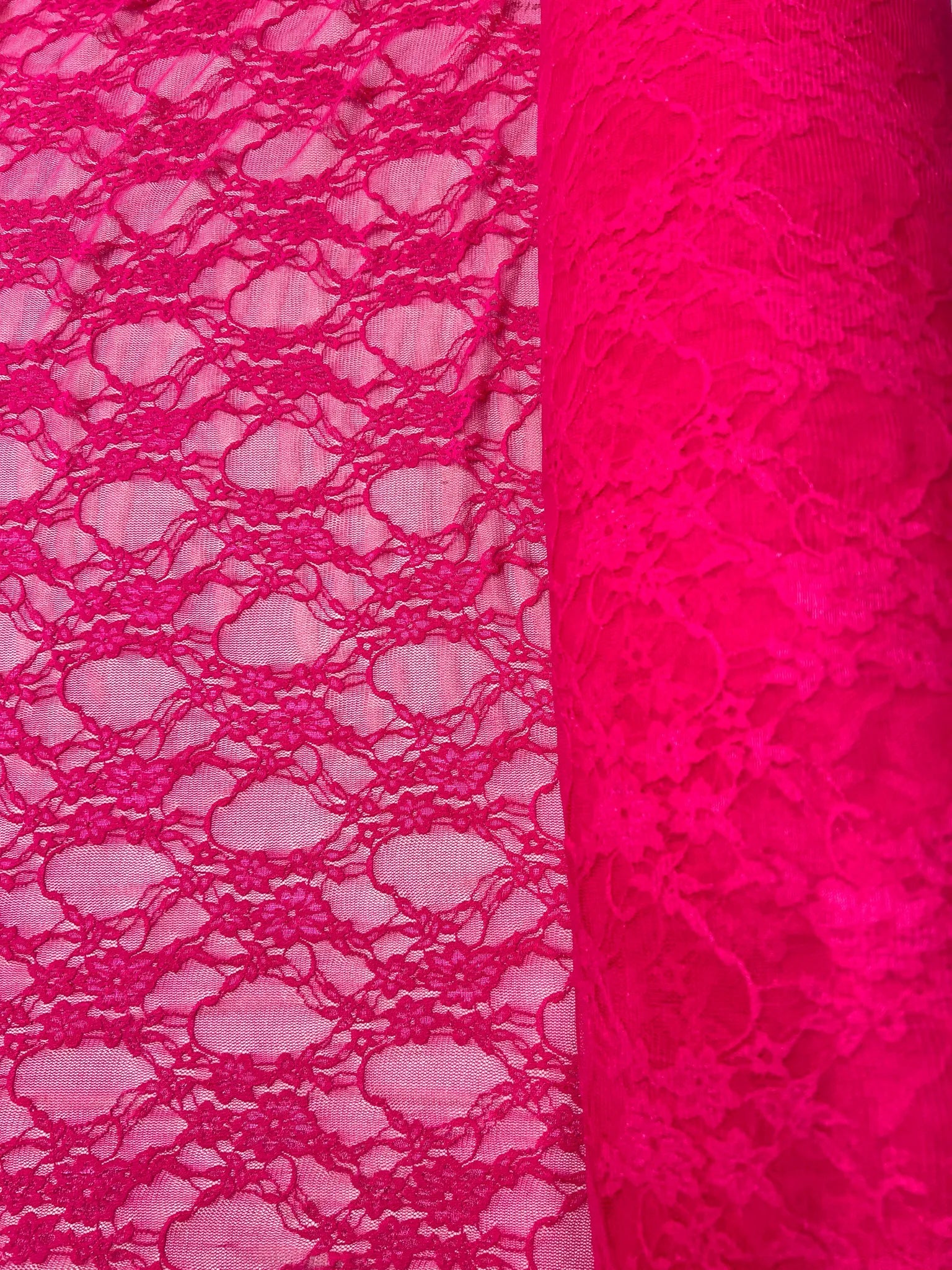 Close-up of delicate floral design on hot pink lace fabric
