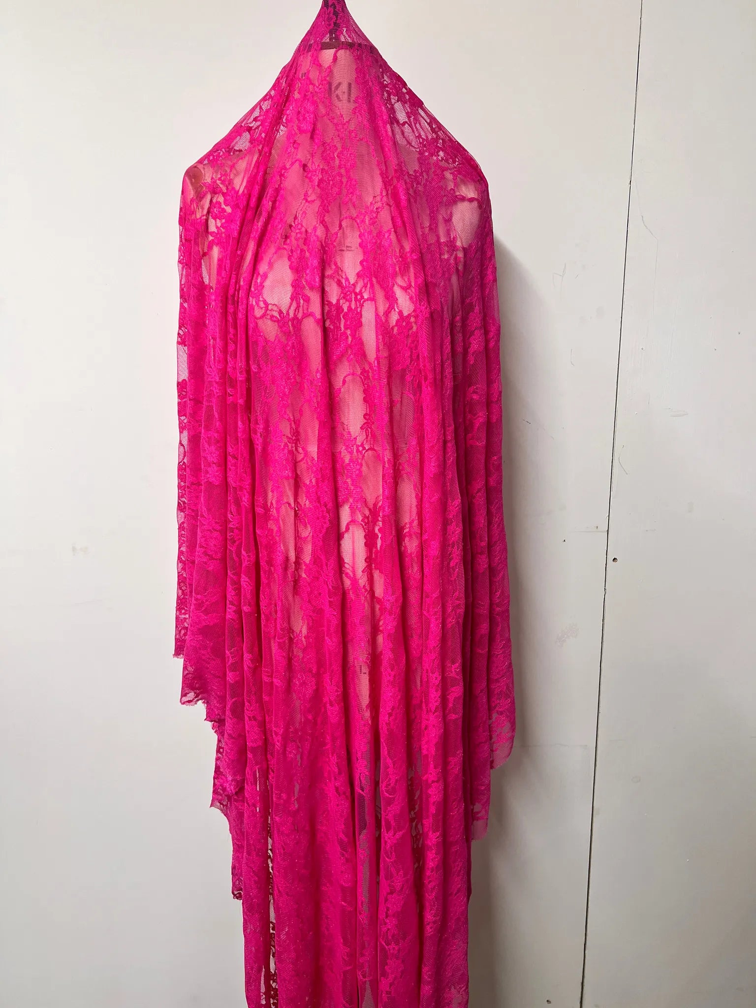 Floral lace fabric in vibrant hot pink for dressmaking