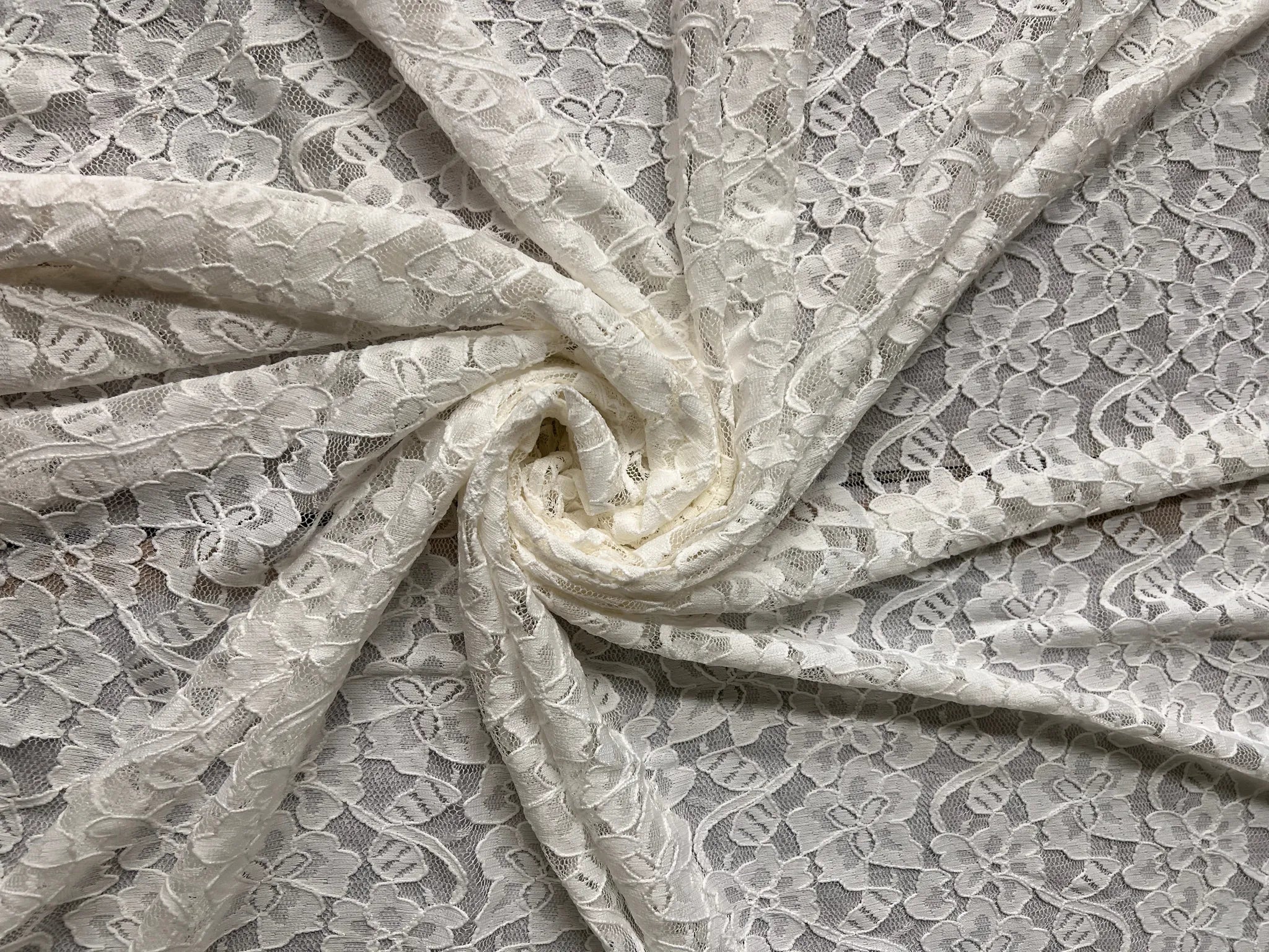 Premium Ice White Floral Lace Fabric draped elegantly.