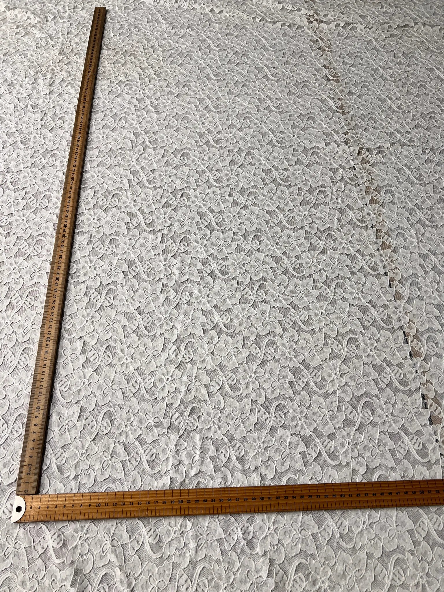 Elegant drape of Ice White Floral Lace Fabric.