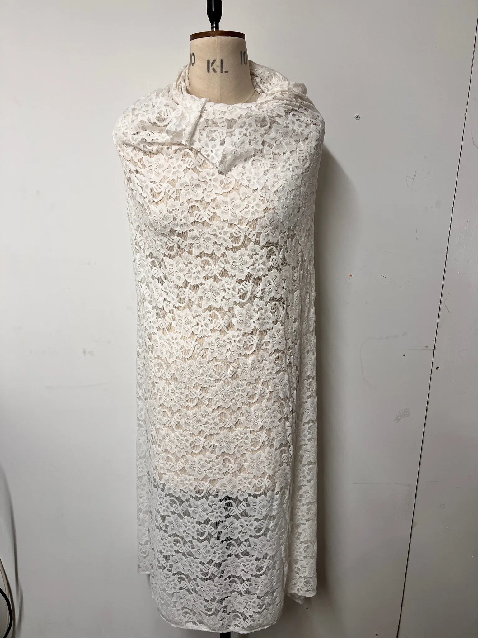 Ice White Floral Lace Fabric displayed on a sewing table.